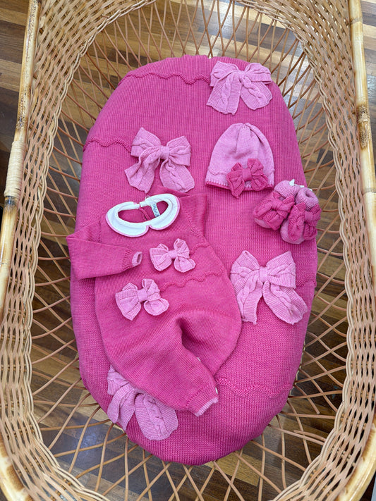 Coordinato nascita Bebè di Almy in lana fucsia con fiocchi rosa in rilievo applicati sul davanti di coperta tutina cappello e babbucce sono l'inverso