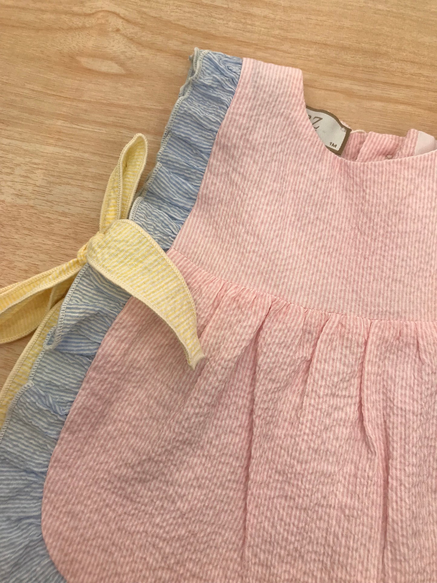Completo Paz Rodriguez in cotone due pezzi casacca rosa con rusche celeste con fiocchi laterali gialli culotte abbinata in rosa