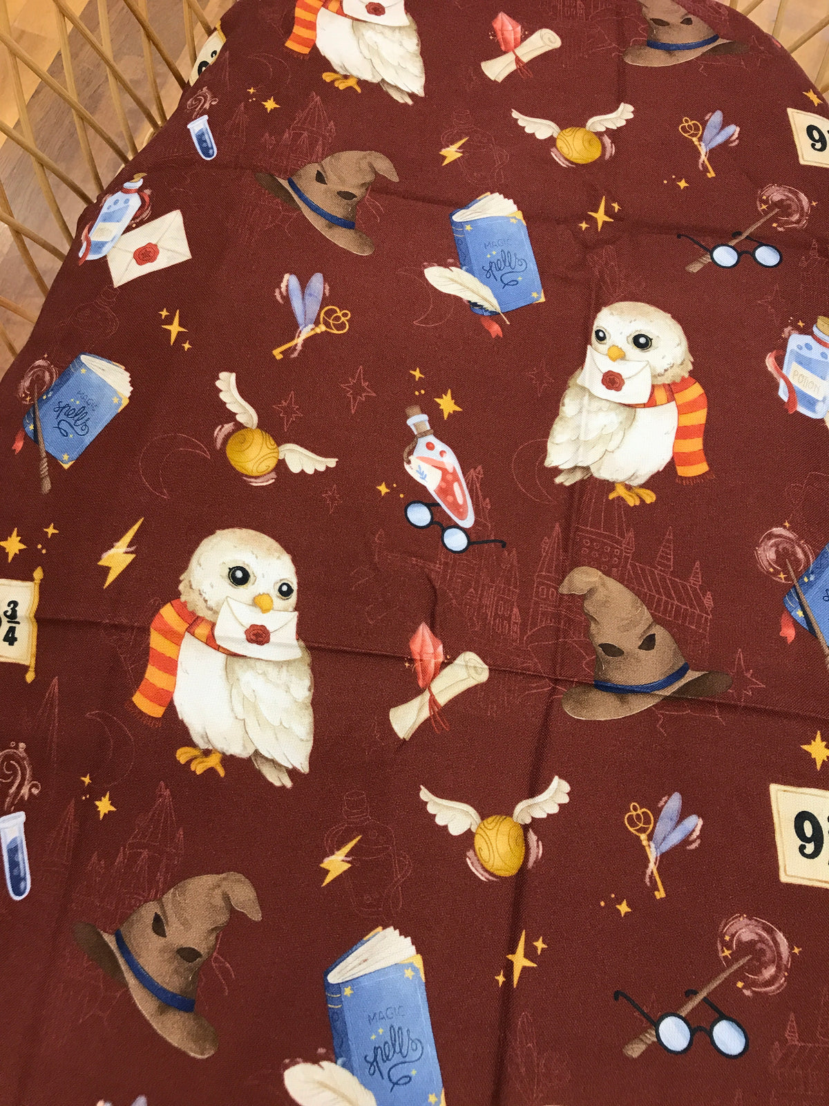 Mussola Nannafrufrù in cotone di bamboo di base borgogna con piccoli animaletti stile harry potter