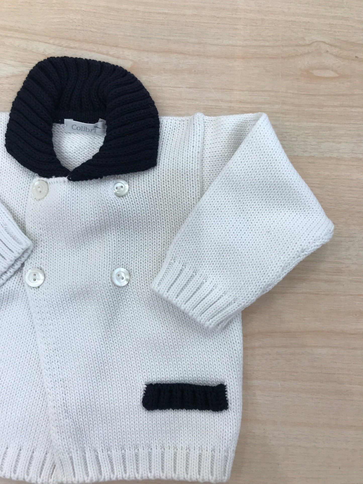 Cardigan Colibrì in filo bianco con colletto blu scuro e tasche rifinite sul blu