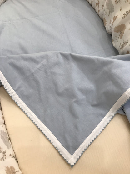 Coperta Martin Aranda in cotone celeste polvere con bordo rifinito in bianco e ricamo celeste
