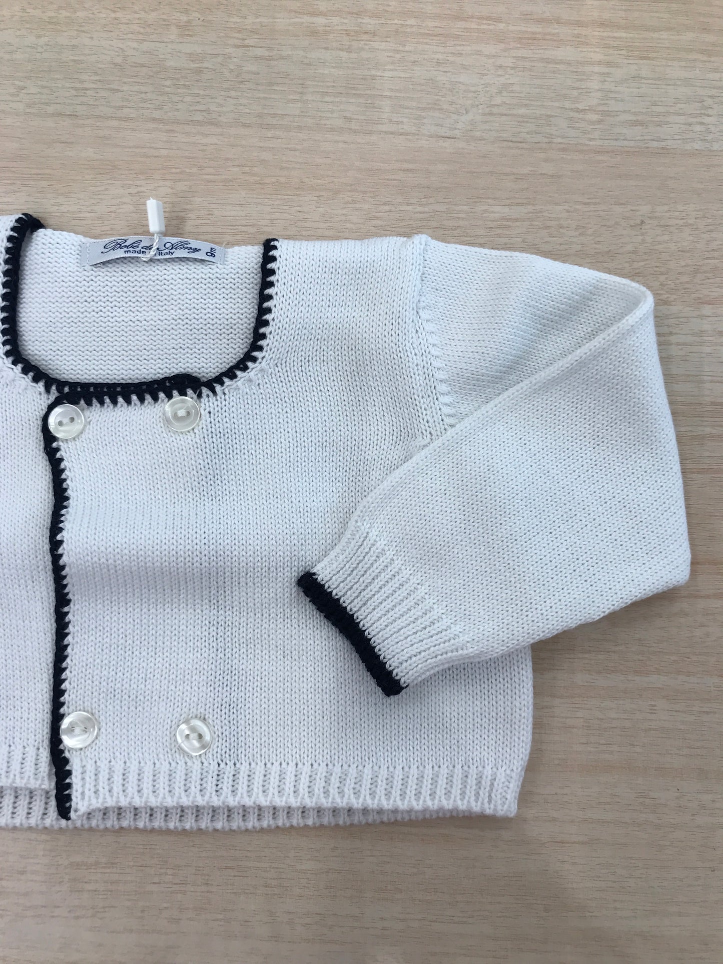 Cardigan Bebè di Almy in filo bianco con rifiniture blu scuro e bottoncini