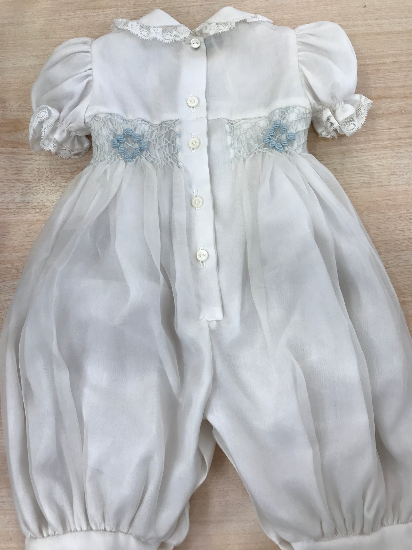 Pagliaccetto Piccola Giuggiola in organza in seta bianco mezza manica a sbuffo con applicazioni di valancienne e piccole rose celesti ricamate