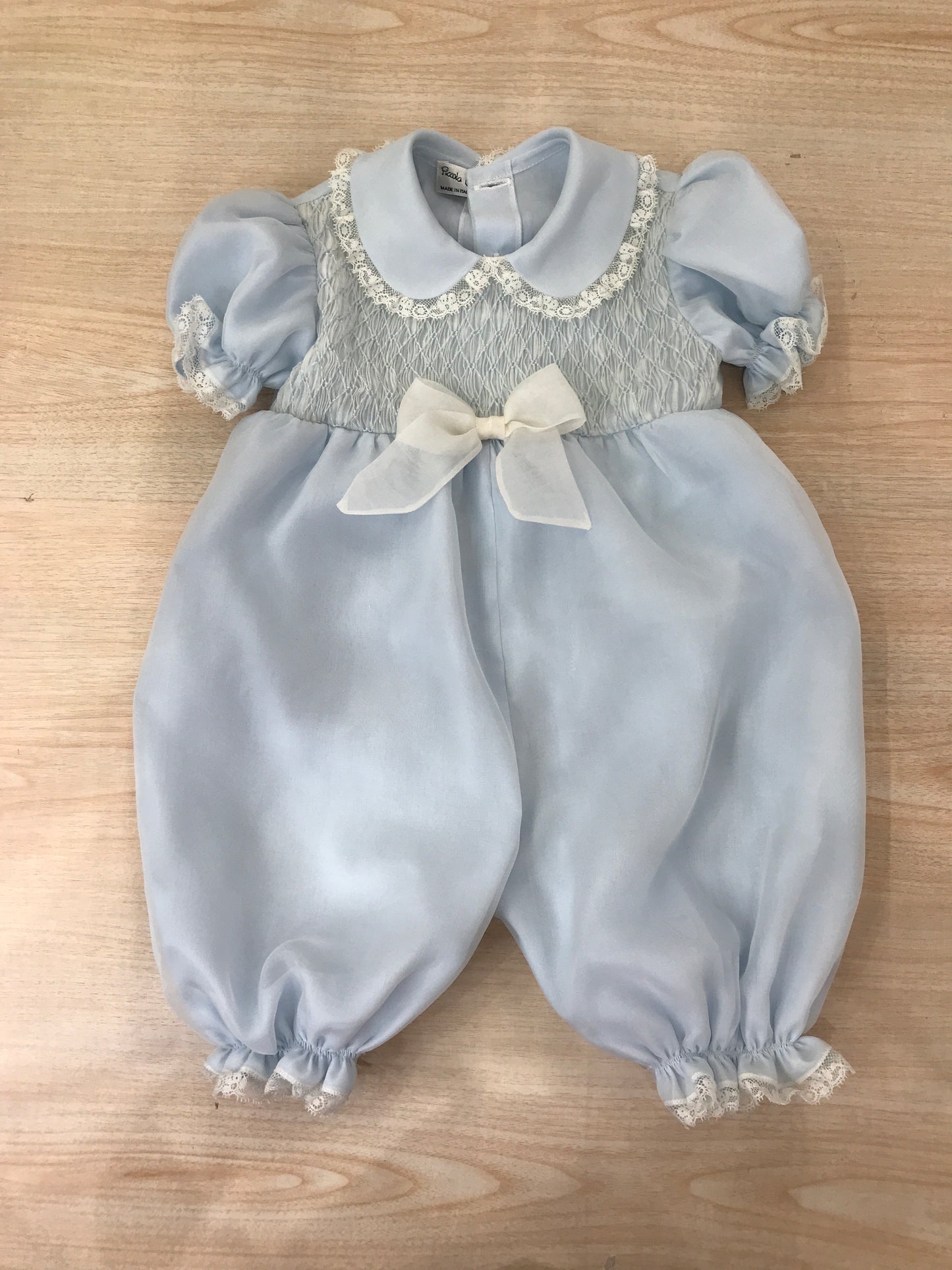 Pagliaccetto Piccola Giuggiola in organza in seta celeste manica a sbuffo con applicazone di valancienne corpetto rifinito da punto smock con fiocco centrale
