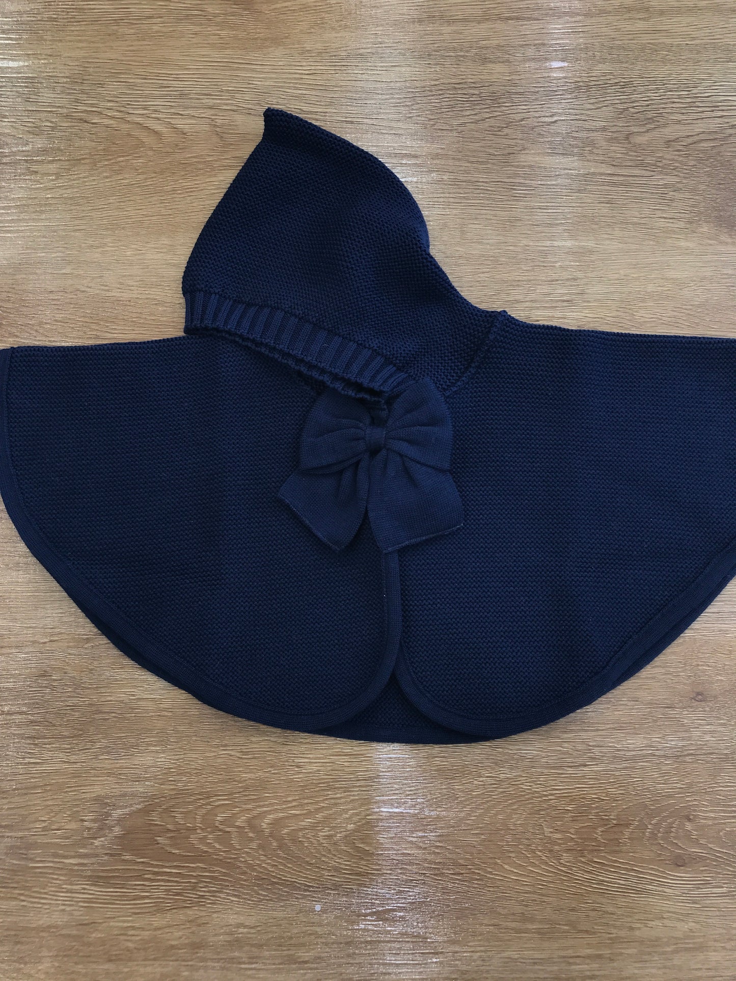 Mantella Baby Lord in lana blu scuro con cappuccio e fiocchetto sul davanti