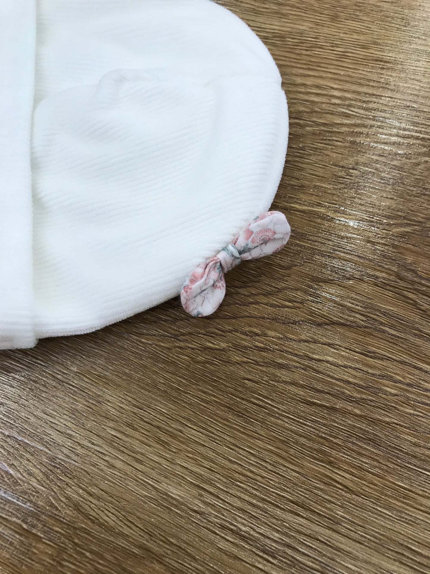 Cappello Nanan in ciniglia con risvolto e fiocchetti laterali con fiori