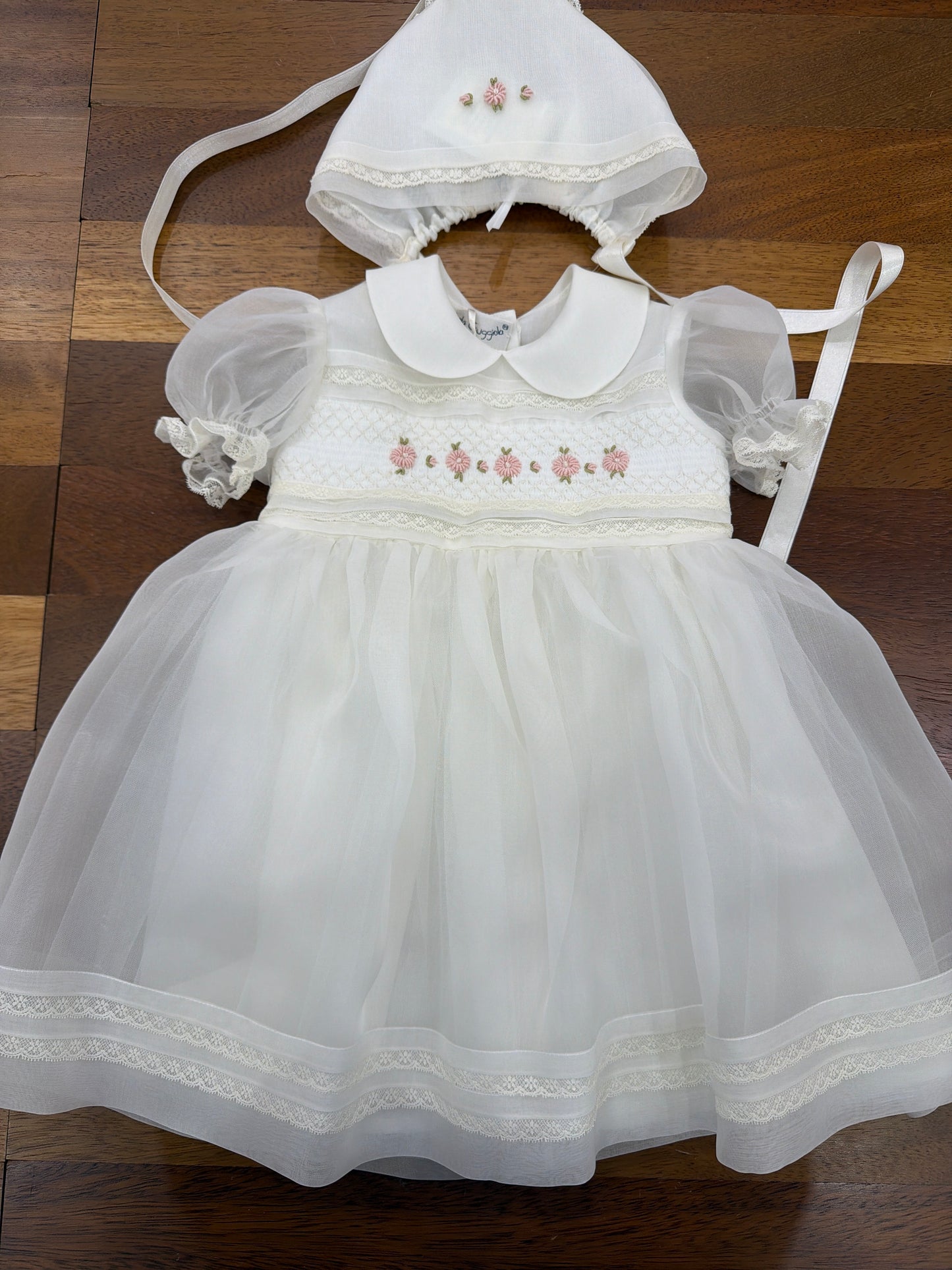 Abito Piccola Giuggiola in organza in seta panna manica corta a sbuffo corpetto lavorato in pizzo con fiori ricamati a mano sul gonnellone pizzo ricamato stessa lavorazione sulla cuffietta