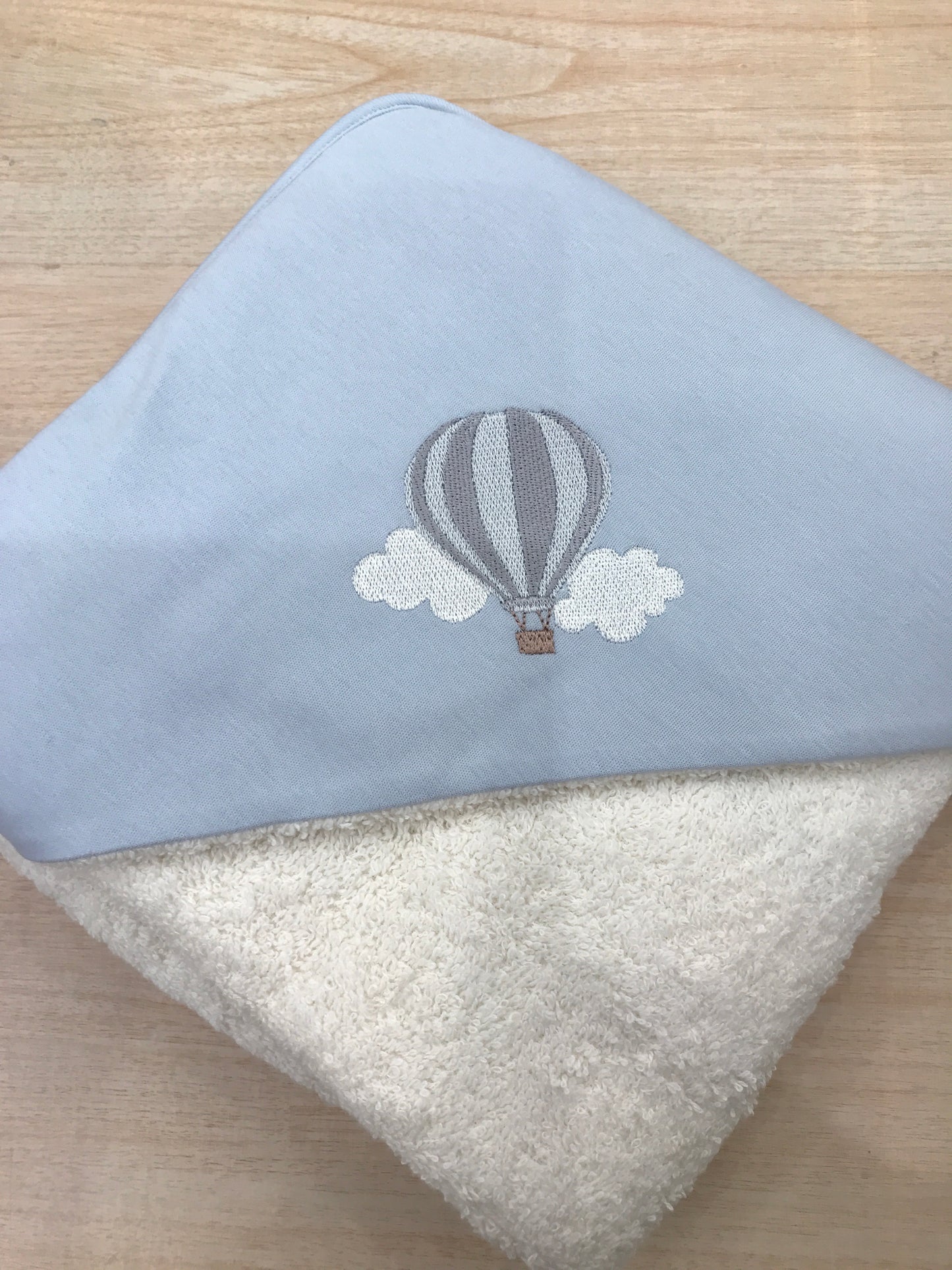 Accappatoio Baby Gi in spugna panna con triangolo celeste polvere con mongolfiera ricamata sul davanti