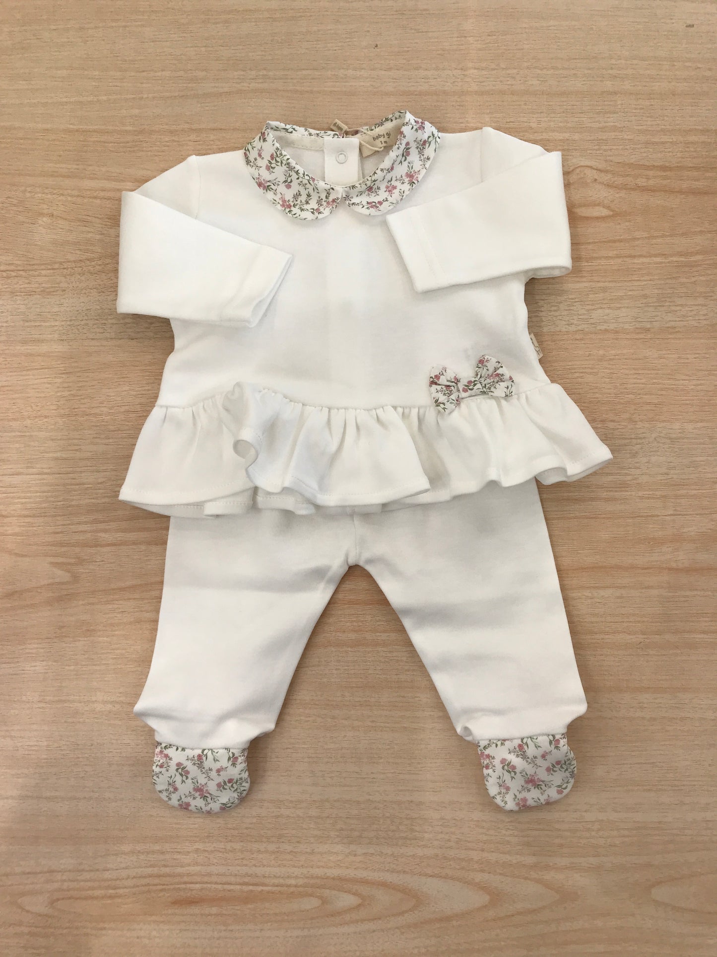 Tutina Baby Gi in cotone due pezzi manica lunga con piedini decorati da fiorellini rusche colletto con fiorellini e fiocchetto laterale in basso