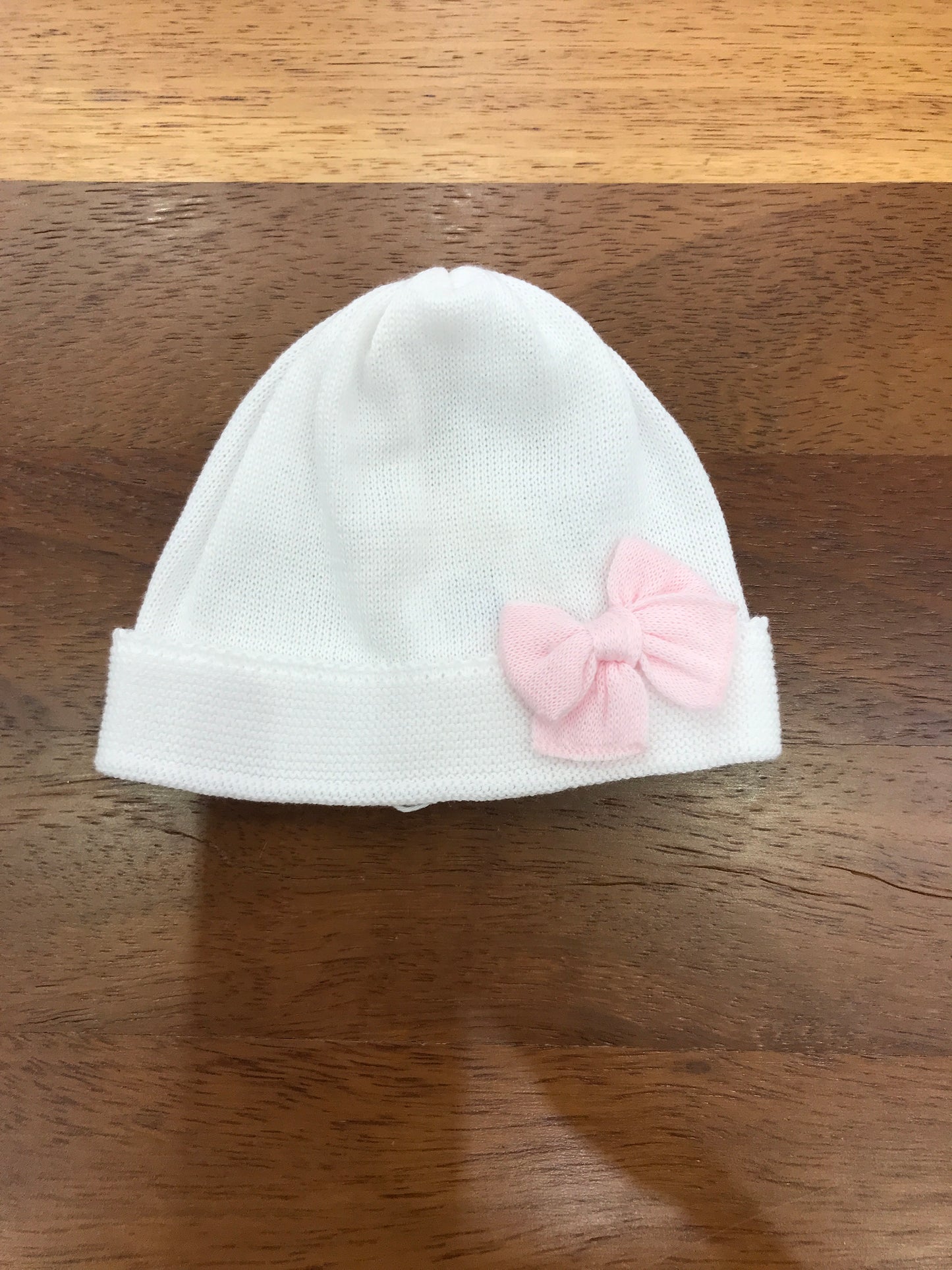 Cappello Baby Lord in filo bianco con risvolto con fiocco rosa applicato