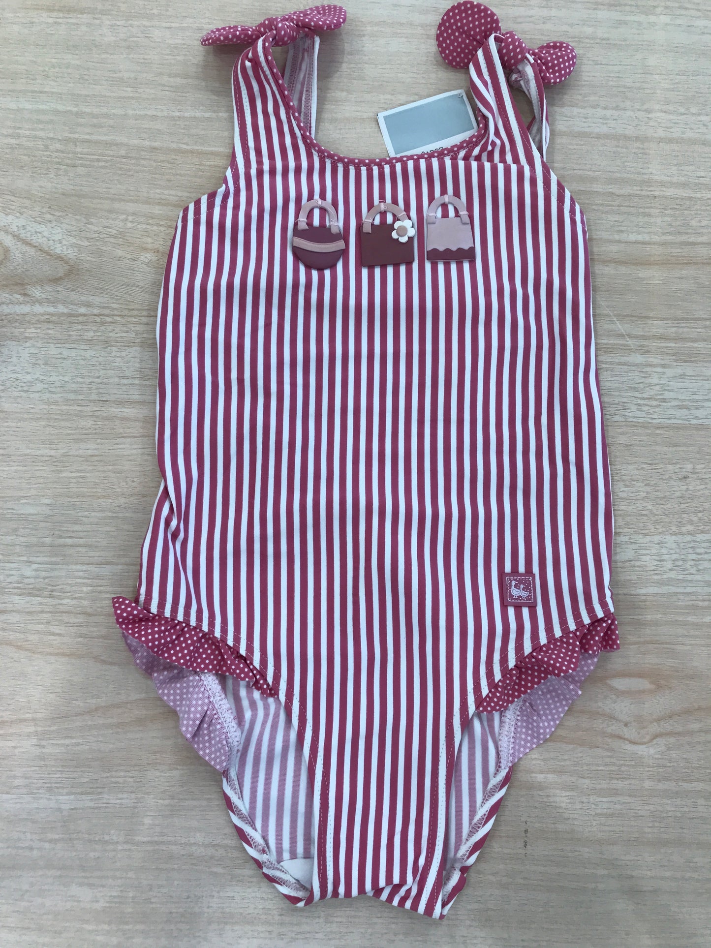 Costume Al Agua Patos intero a righe bianche e fucsia con bretelle con fiocchetto e rusche