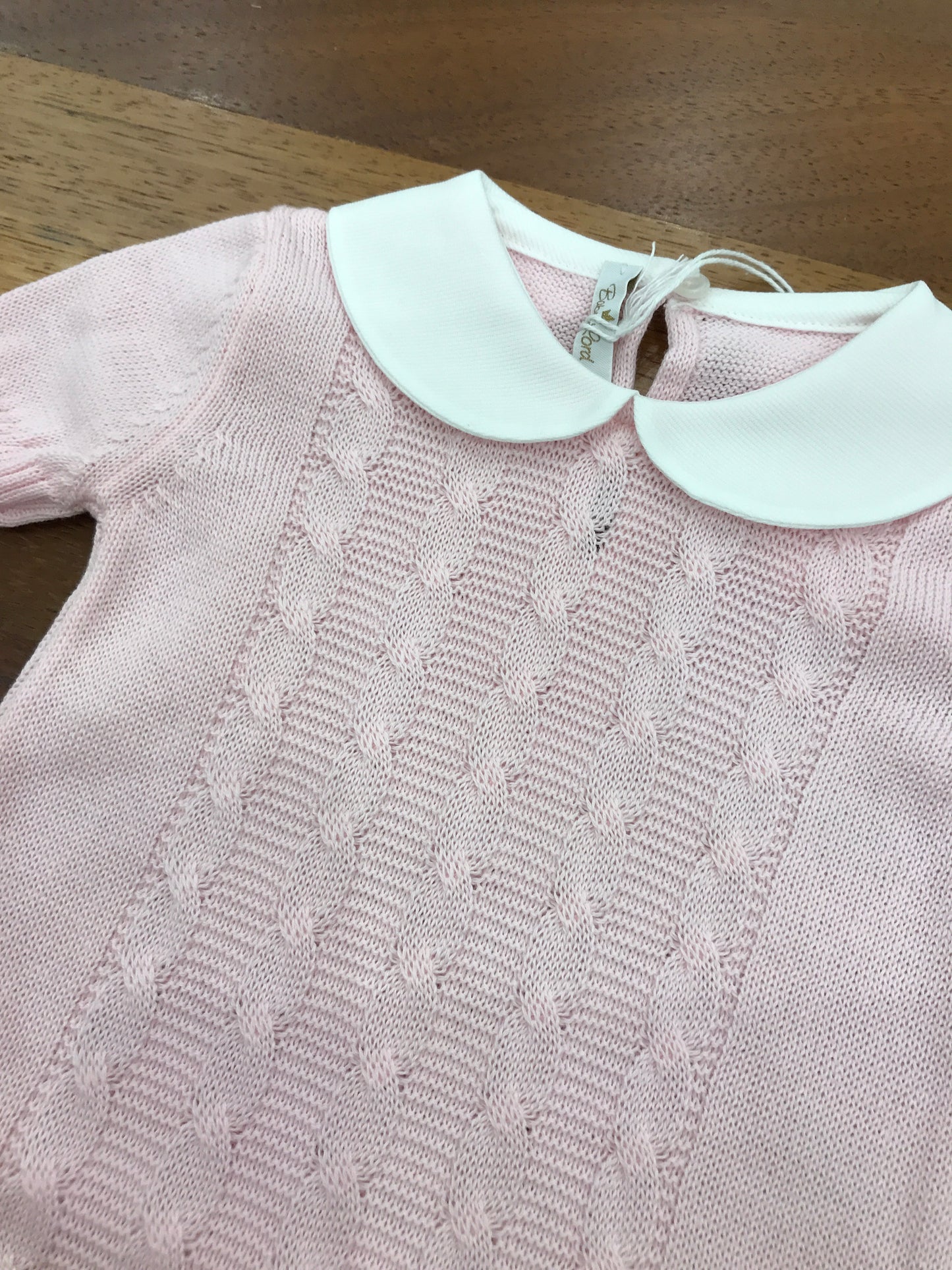 Pagliaccetto Baby Lord in filo rosa mezza manica con lavorazione di trecce sul davanti