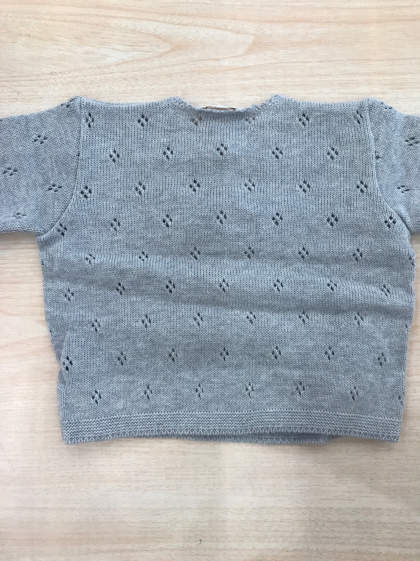 Cardigan Baby Lord in filo grigio ad incrocio traforato con due fiori sul davanti