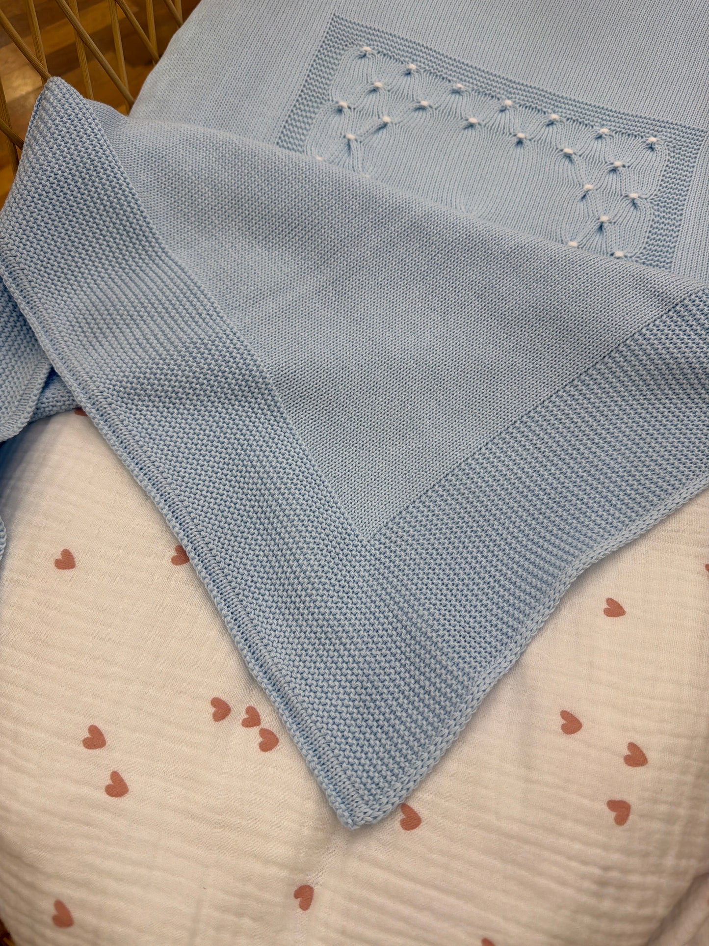 Coperta Baby Lord in filo celeste con lavorazione di punto smock bianco sul davanti