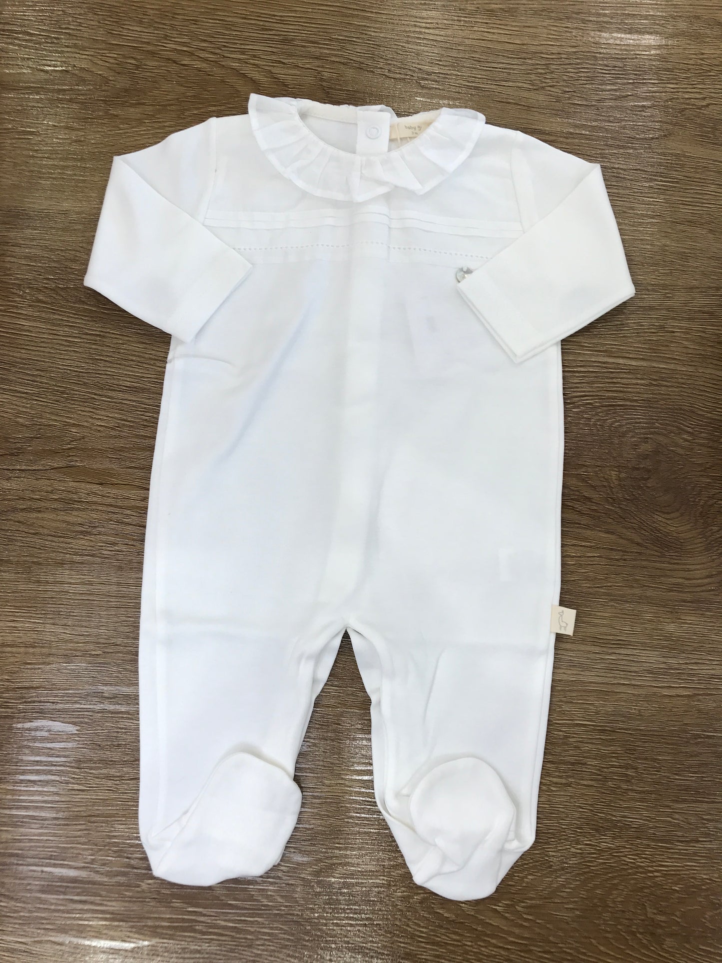 Tutina Baby Gi in cotone panna con rusche e ricamo centrale