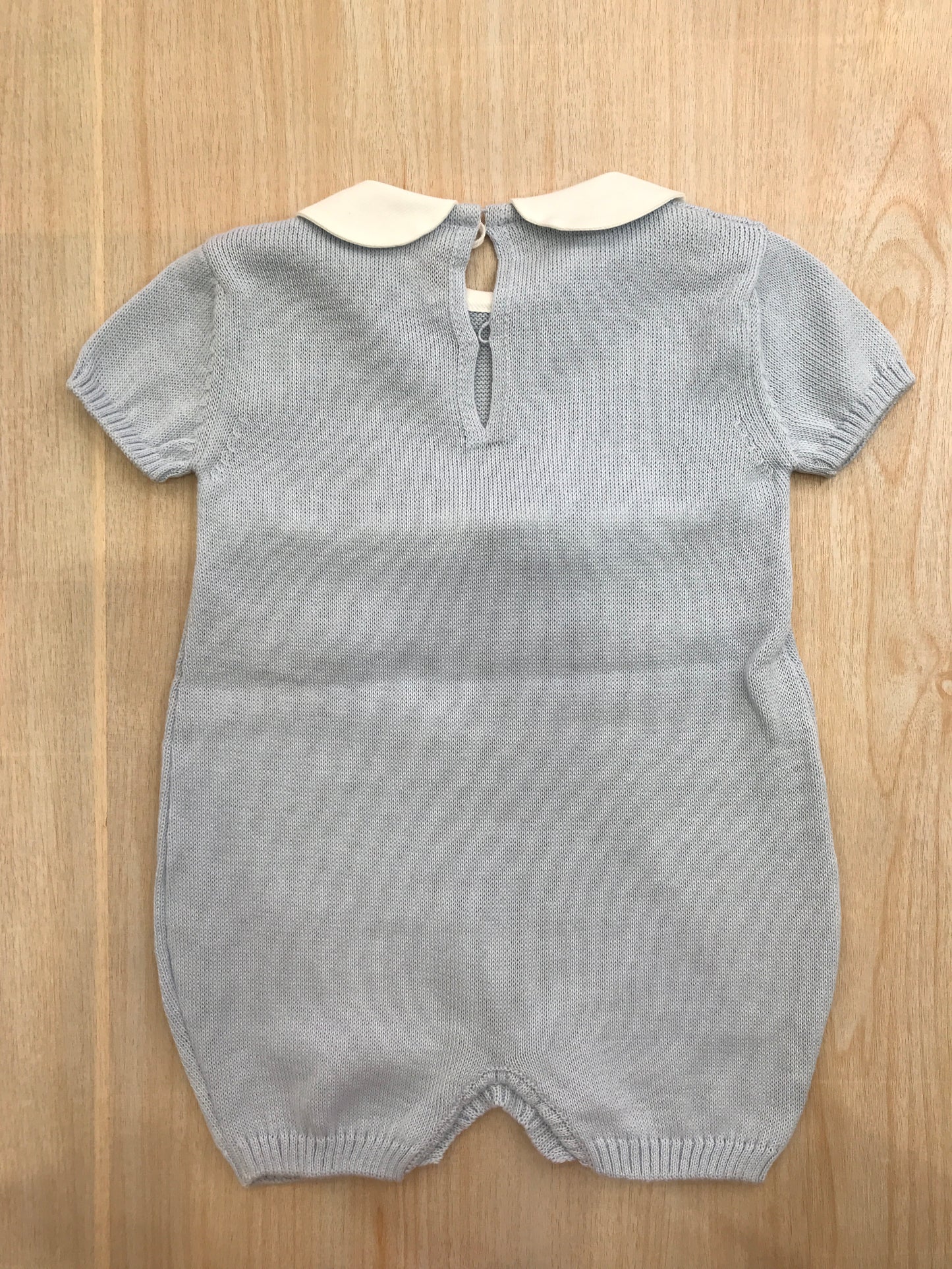 Pagliaccetto Baby Lord in filo celeste con fiocco bianco sul davanti e collo tondo bianco con pois celesti