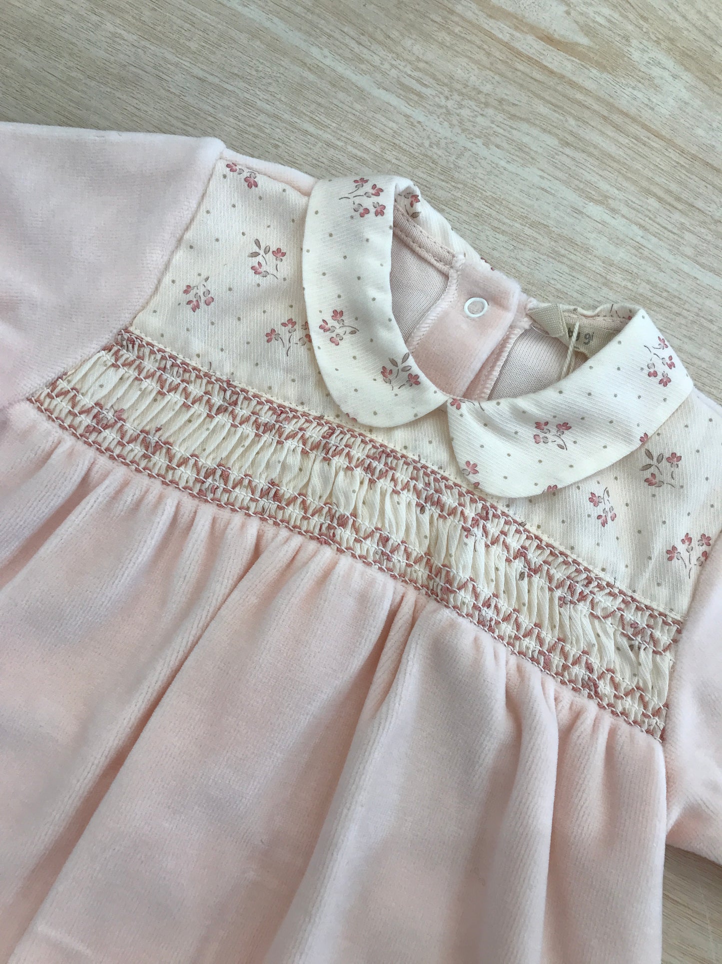 Tutina Baby Gi in ciniglia rosa pesca intera con lavorazione di punto smock e fiorellini