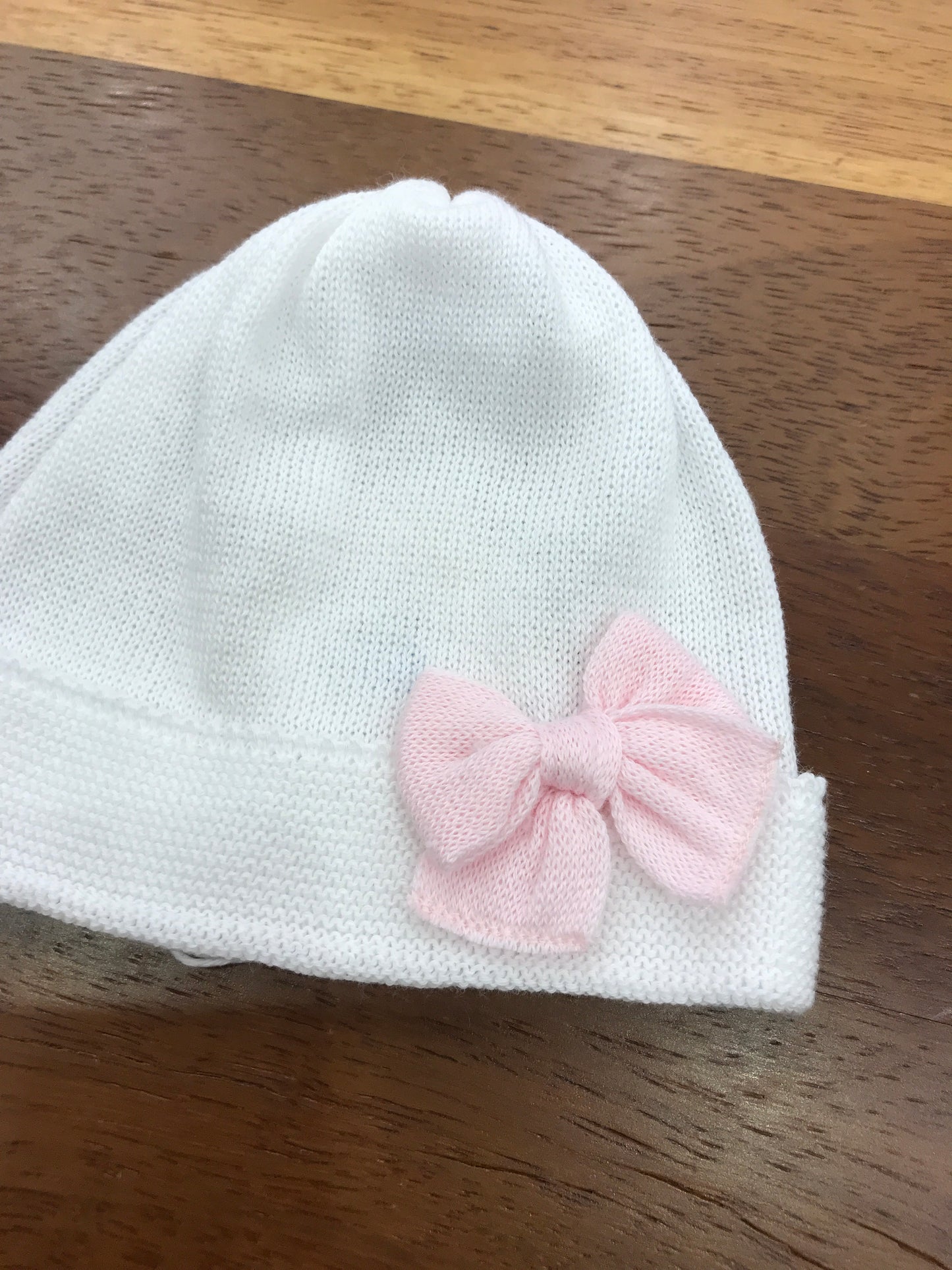 Cappello Baby Lord in filo bianco con risvolto con fiocco rosa applicato