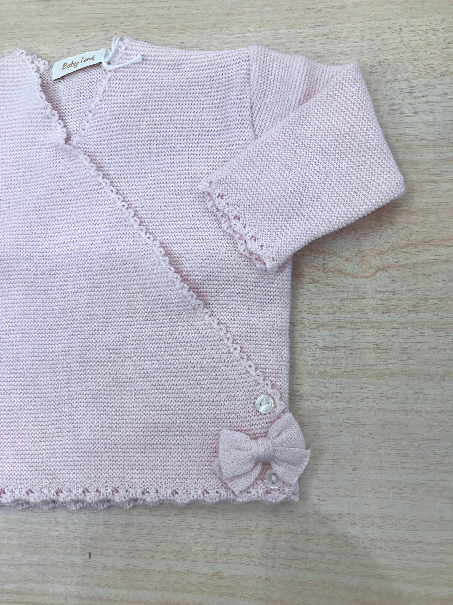 Cardigan Baby Lord in filo rosa chiusura ad incrocio con fiocchetti ai due lati