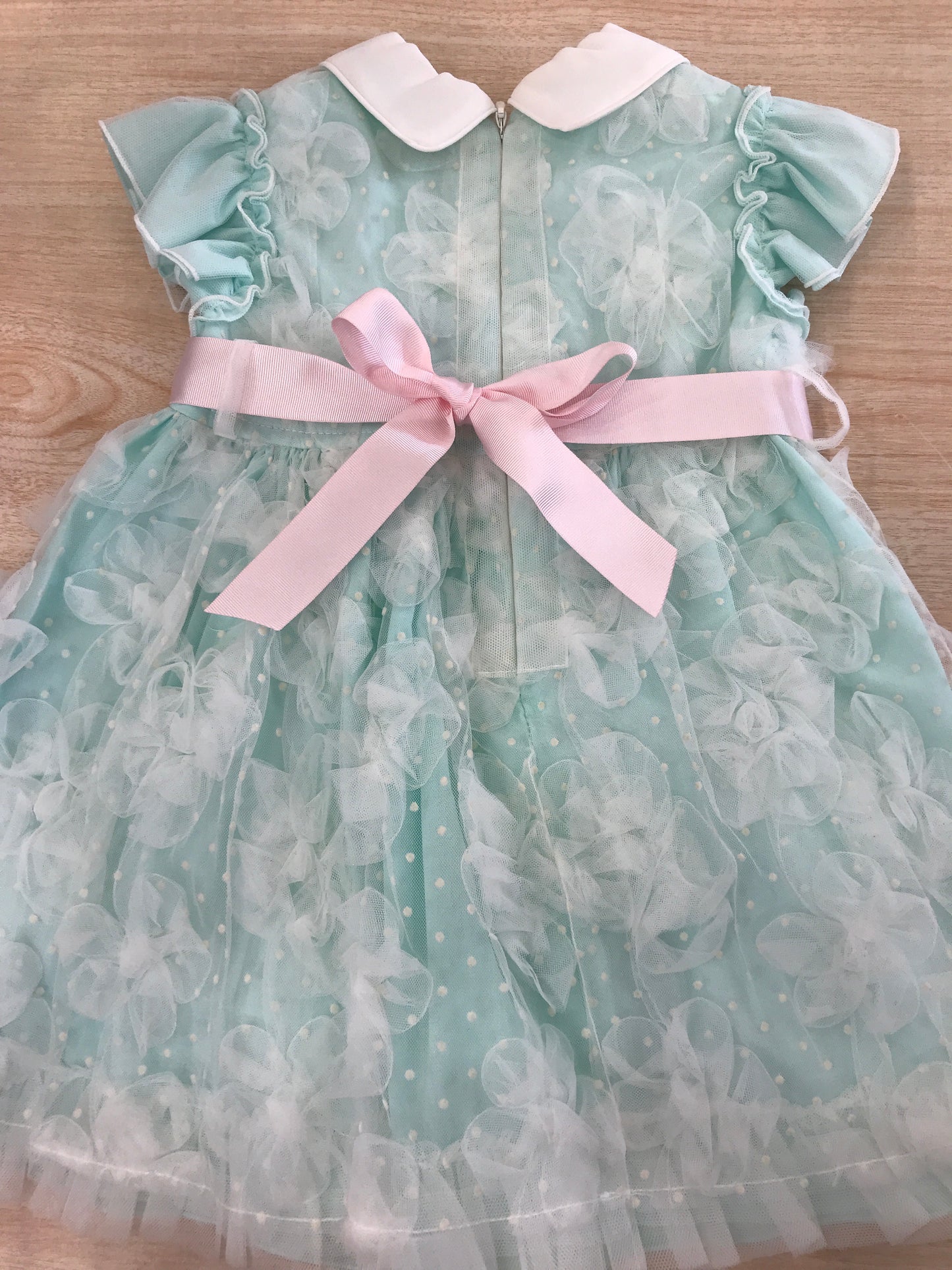 Abito Cielo Blu in cotone rivestito da tulle con tanti piccoli fiocchi e pois smanicato con rusche con fiocco rosa sul davanti e retro