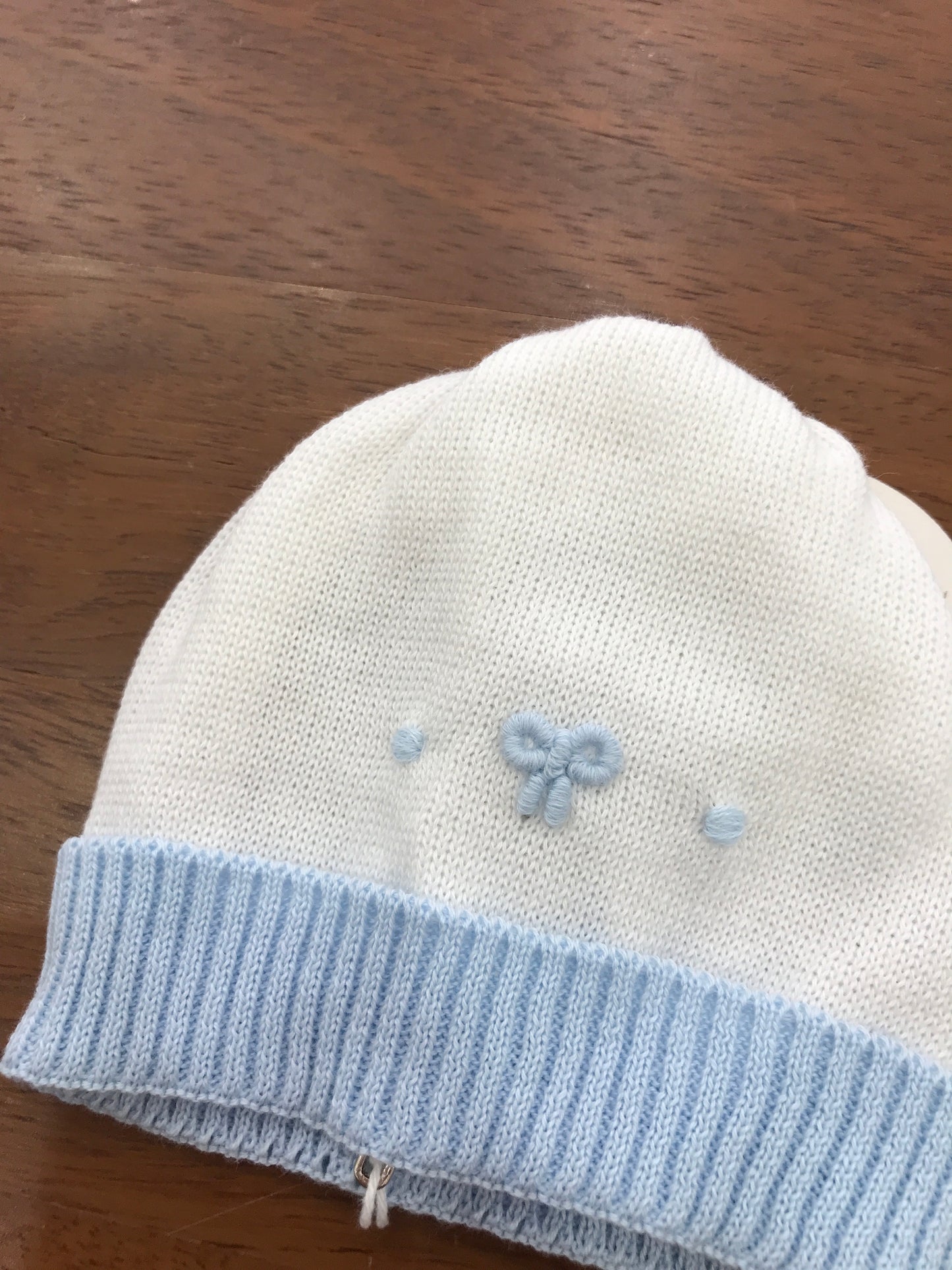 Cappello Baby Lord infilo bianco con risvolto celeste con fiocco e pois ricamati