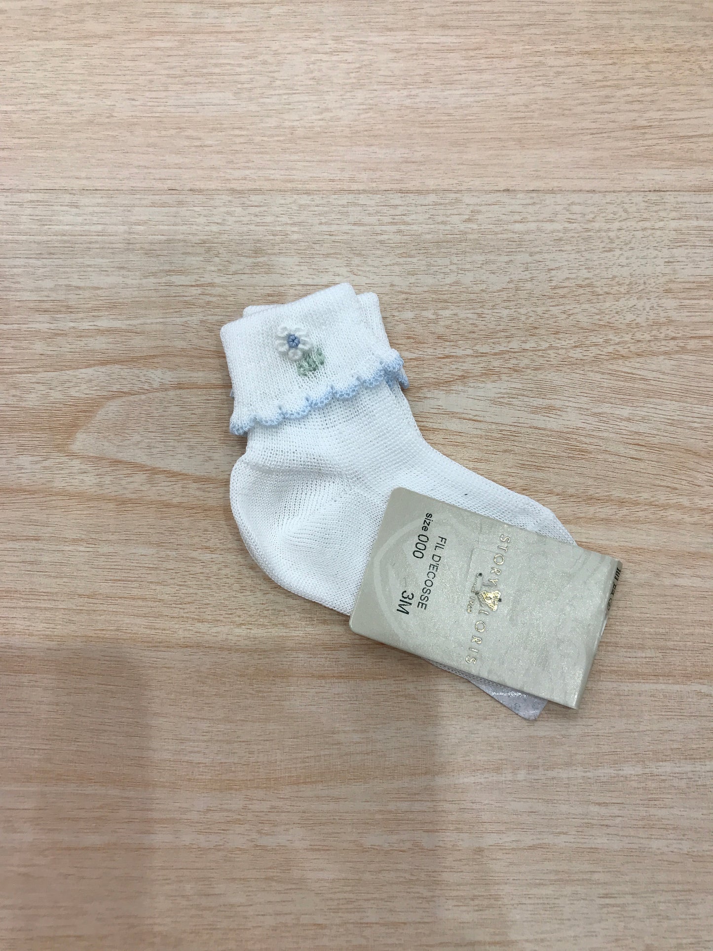 Calzino Story Loris in filo bianco con smerlo celeste con margherita ricamata a mano