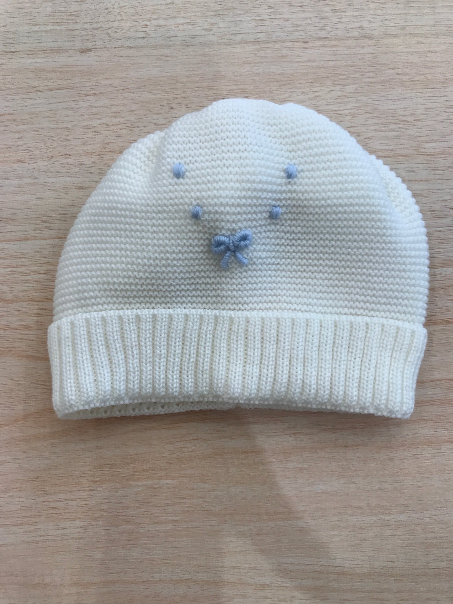Cappello Baby Lord in lana panna con risvolto e nodi d'amore celesti