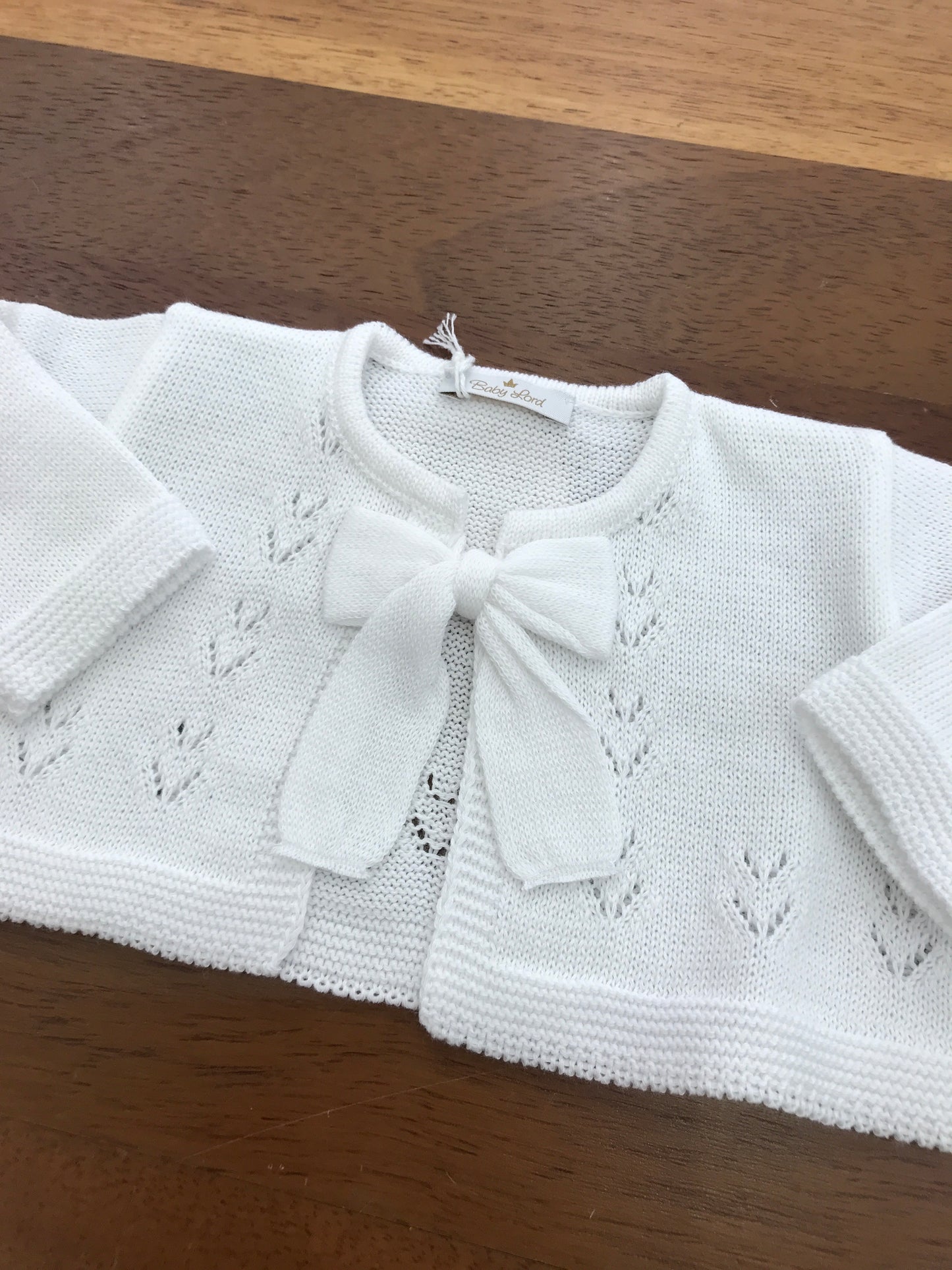 Cardigan Baby Lord in filo bianco manica lunga con fiocco e lavorazione sul davanti