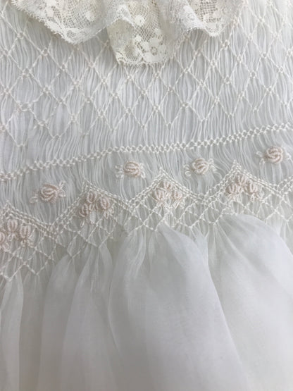 Abito lungo Piccola Giuggiola in organza in seta con gonna lavorata da pizzo corpetto manica lunga con lavorazione di punto smock e roselline ricamate a mano con cuffia coordinata e con punto smock