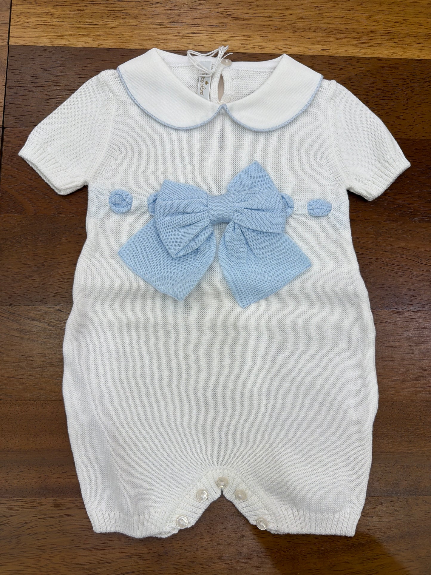 Pagliaccetto Baby Lord in filo bianco con passanastro celeste e fiocco centrale sul davanti mezza manica collo tondo bianco