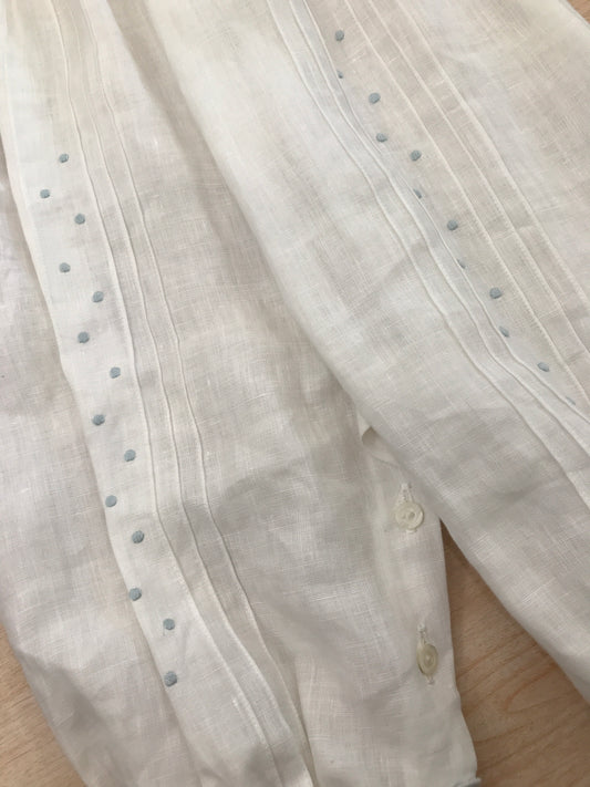 Pagliaccetto Piccola Giuggiola in lino bianco mezza manica con pieghe sul corpetto con pois celesti sulle gambine