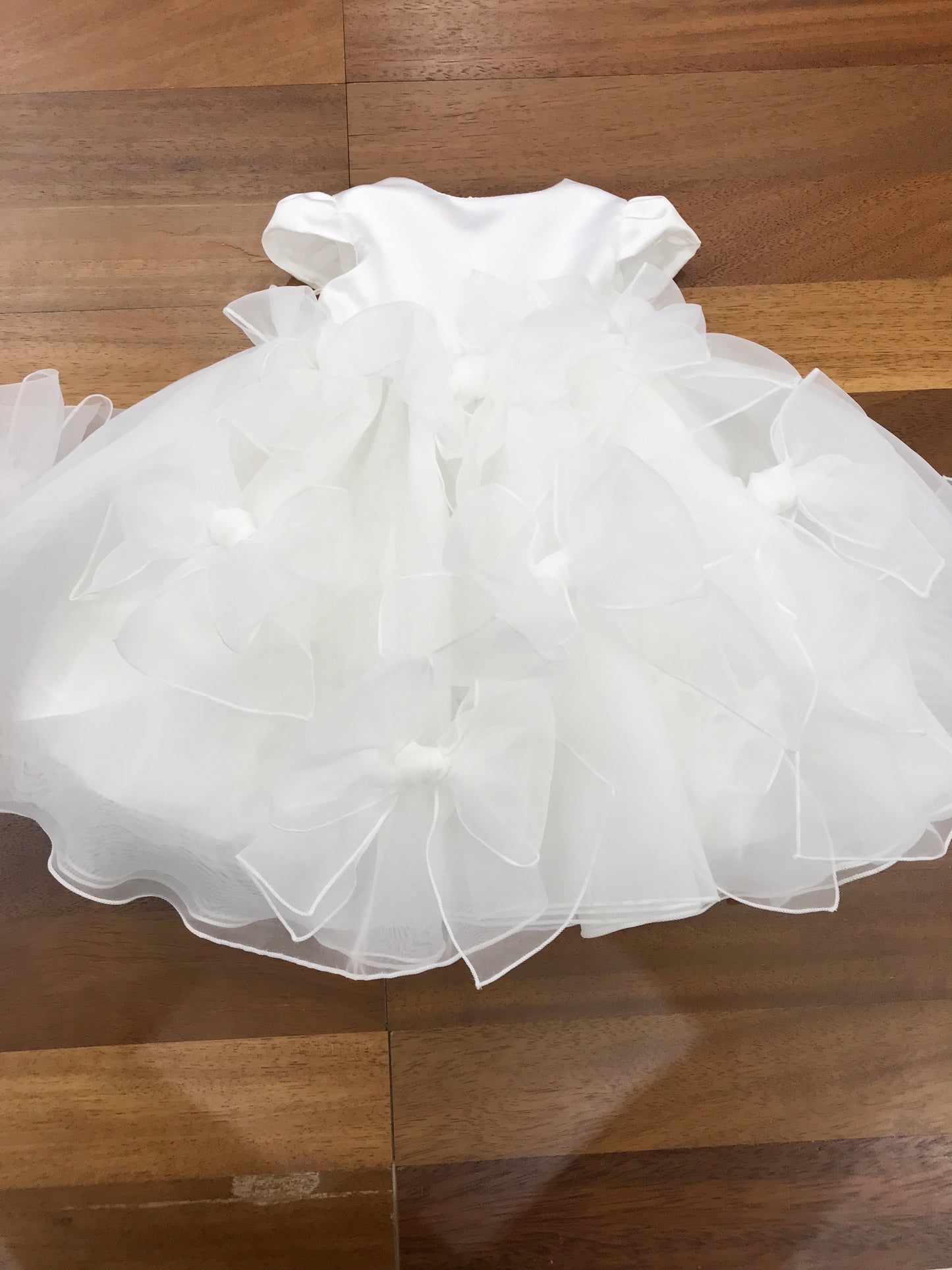 Abito Pure da cerimonia in organza con fiocchi presenti su tutto il gonnellone