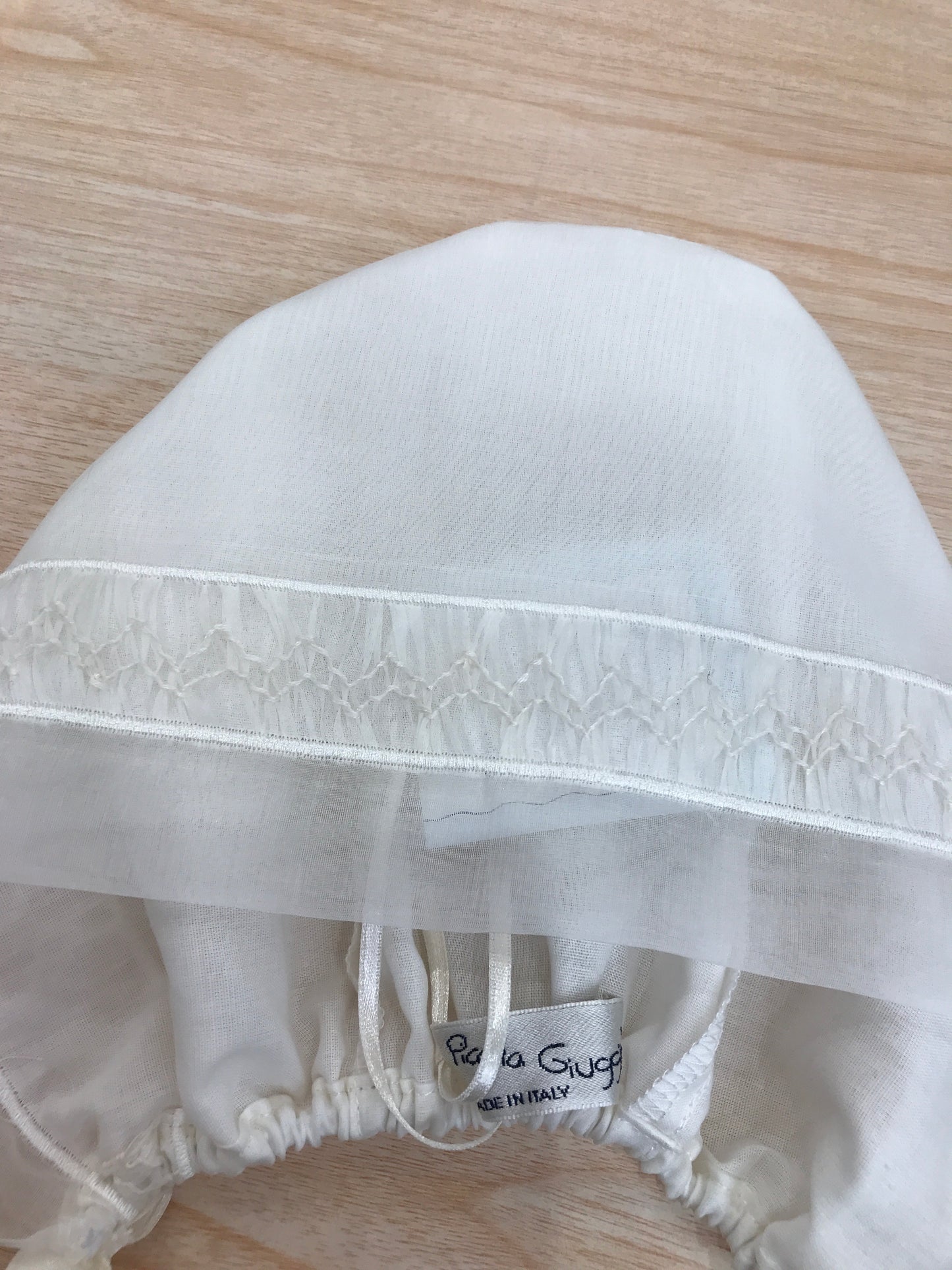 Cuffia Piccola Giuggiola in organza panna con lavorazione di punto smock sul davanti