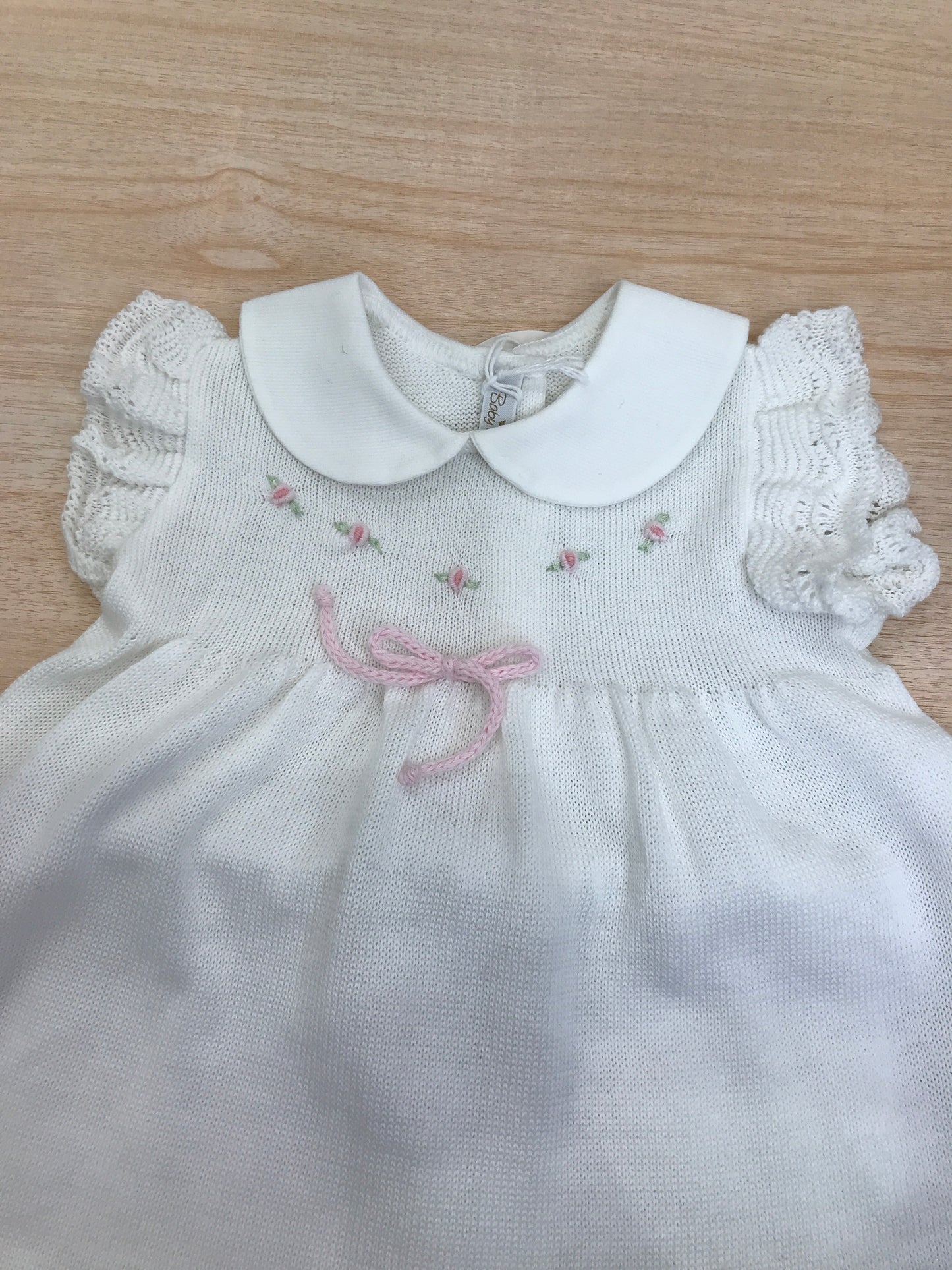 Completo Baby Lord in filo bianco due pezzi smanicato con rusche collo tondo roselline ricamate sul petto e fiocchetto rosa