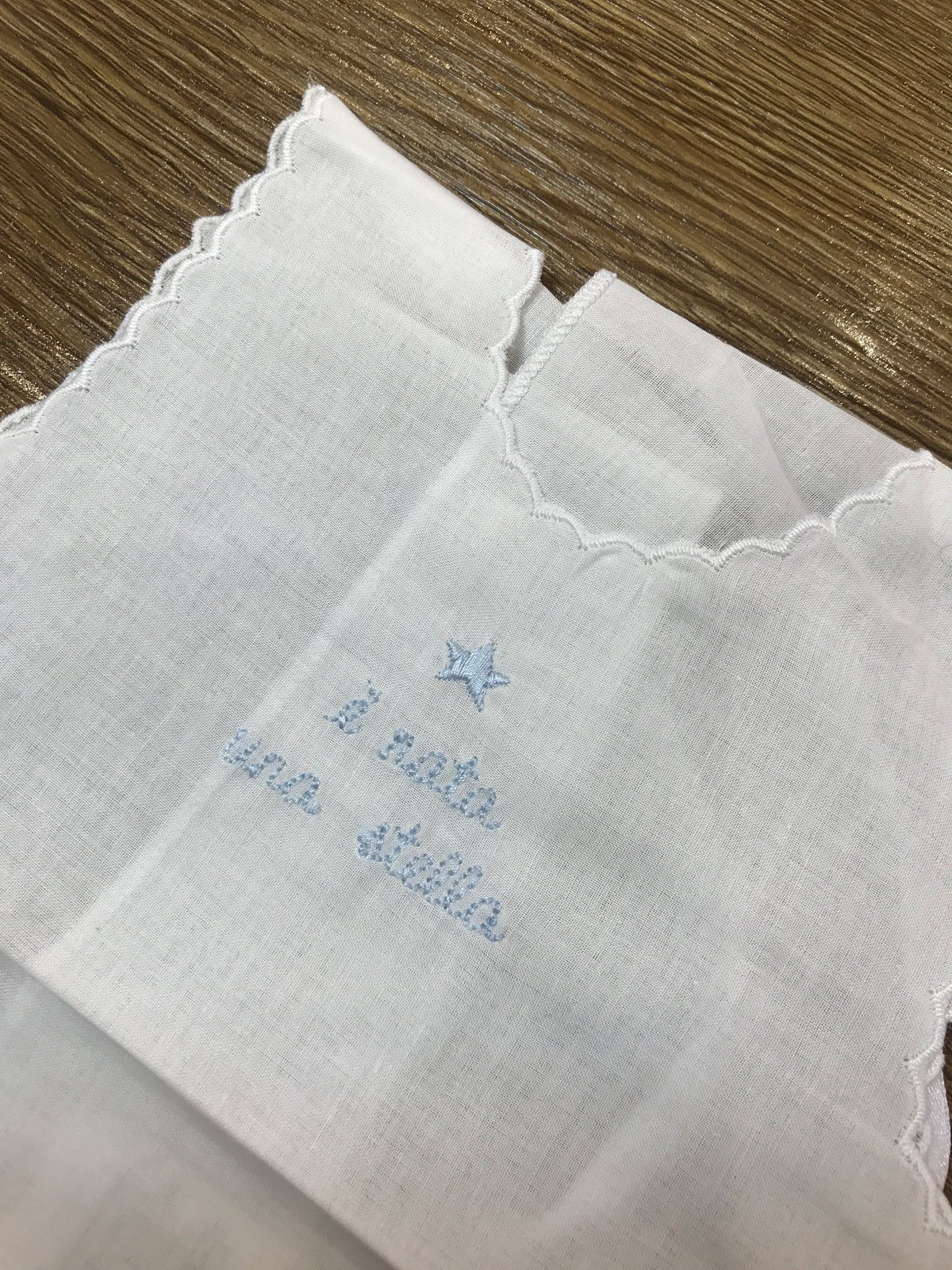 Camicino Coccodè in cotone di battista bianco con ricamo celeste centrale " e nata una stella" e stellina ricamata