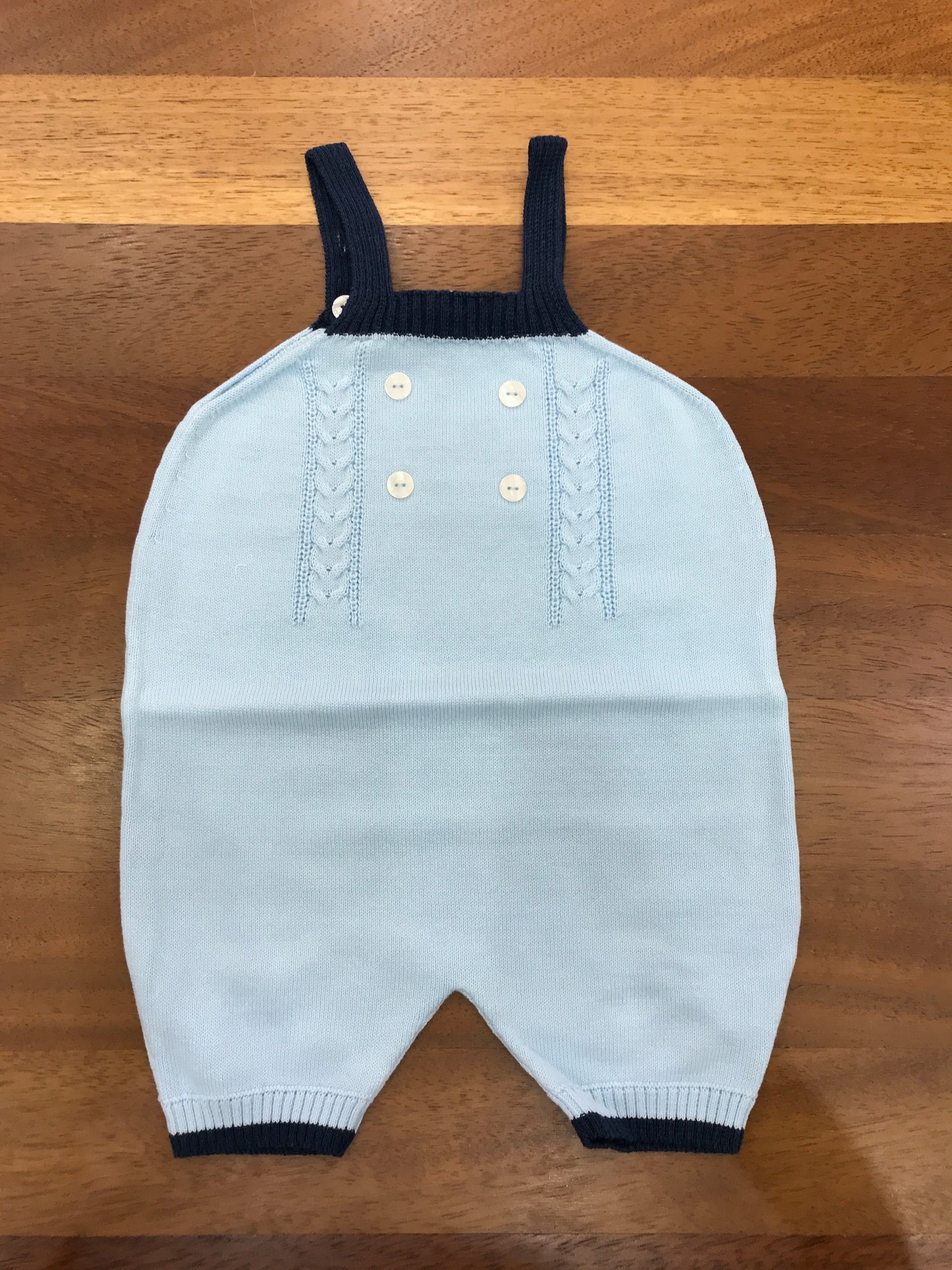 Salopette Coccodè in filo celeste con dettagli blu con bretelle lavorazione di trecce sul davanti con piccoli bottoncini