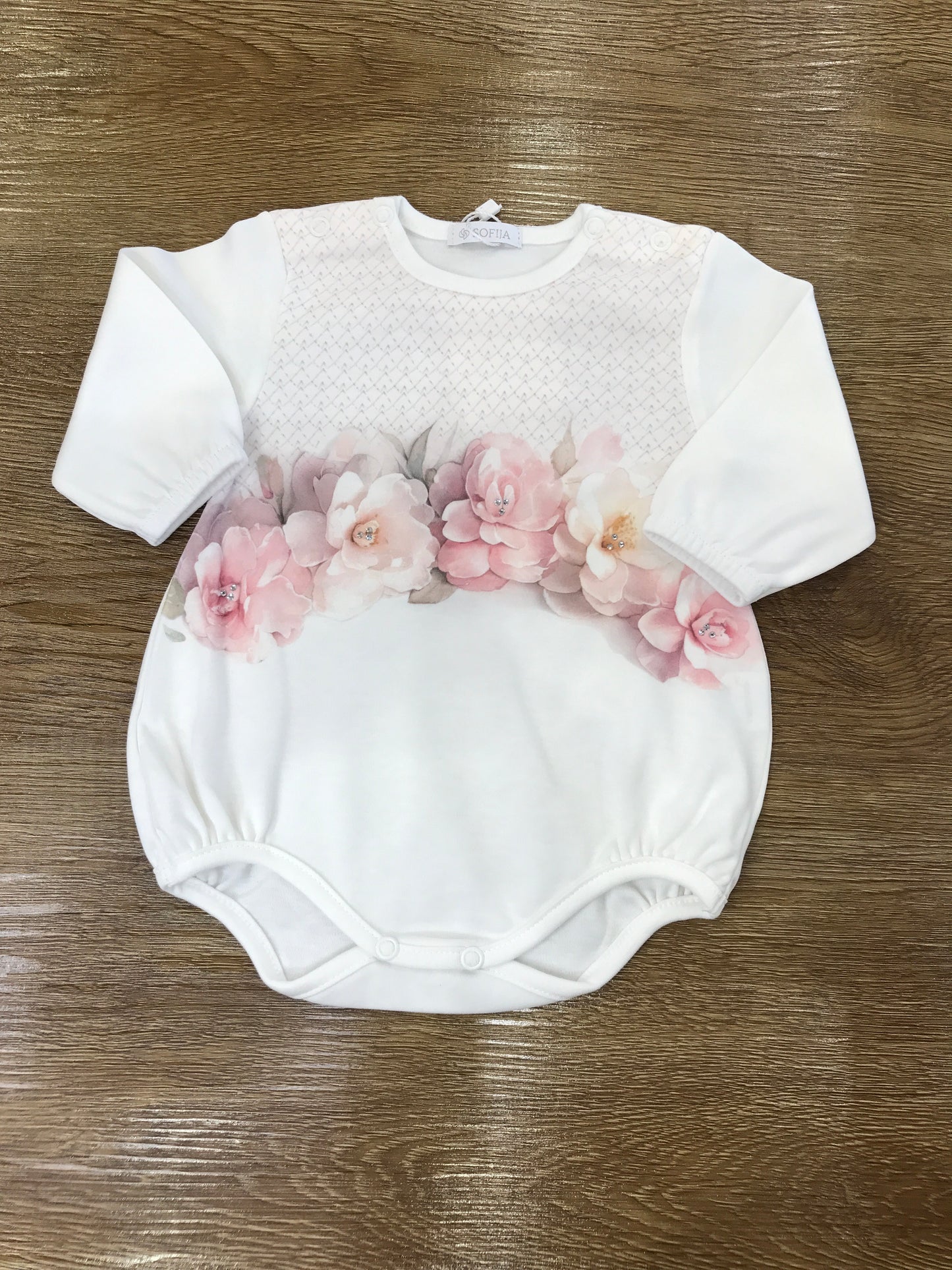 Pagliaccetto Sofija in caldo cotone manica lunga con fiori in rosa sul davanti