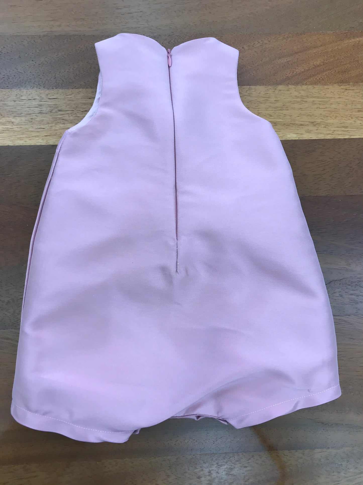 Pagliaccetto a'lapage in raso smanicato con zip sul retro e fiori applicati al centro davanti