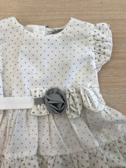 Abito Nanan in cotone bianco a pois grigi smanicato con rusche con fiori applicati lateralmente
