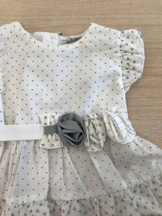 Abito Nanan in cotone bianco a pois grigi smanicato con rusche con fiori applicati lateralmente