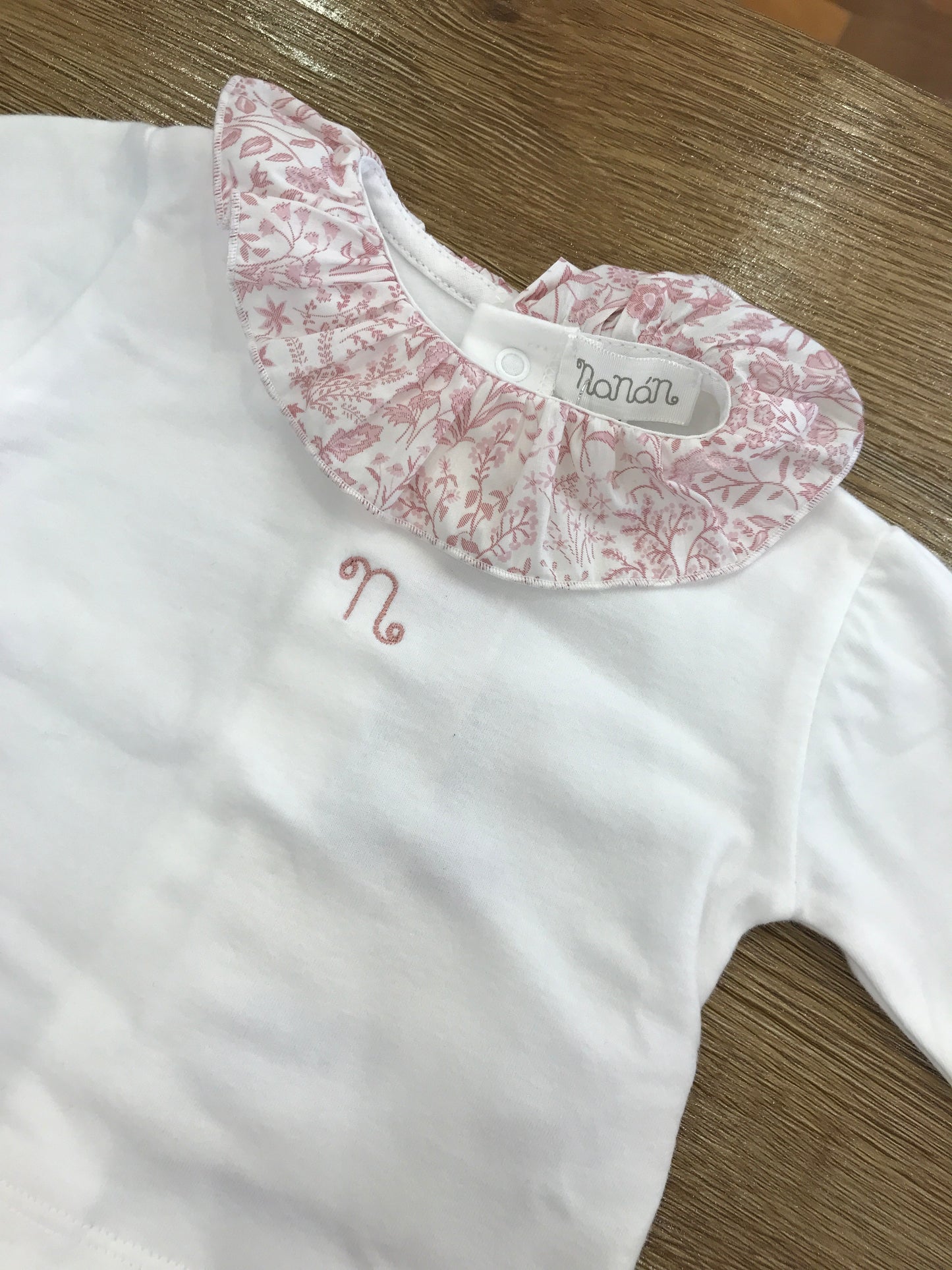 Tutina Nanan due pezzi in caldo cotone con piedini e rusche al colletto con fiori rosa e cappello panna abbinato