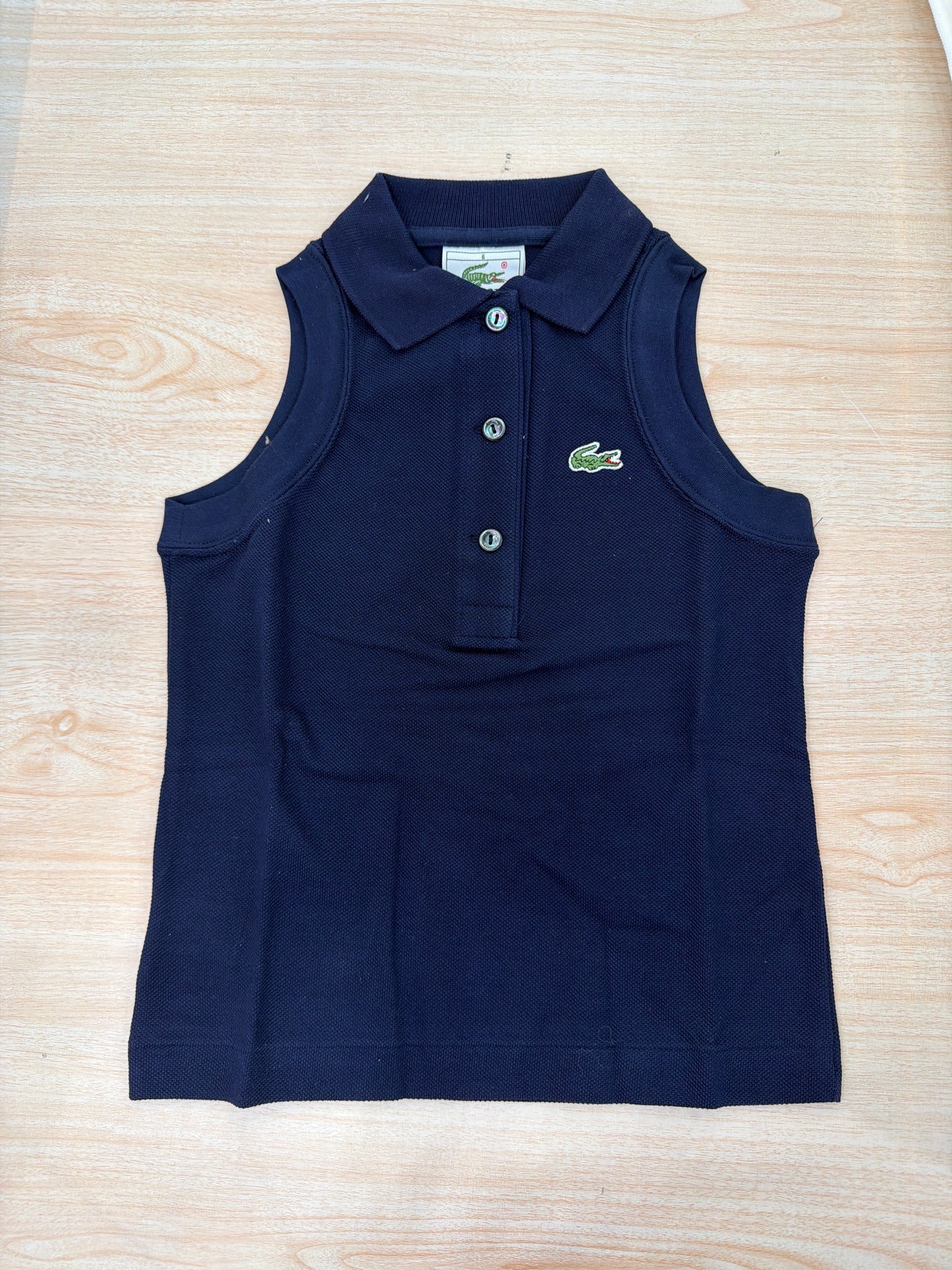 Polo Lacoste in cotone smanicata con bottoncini e logo ricamato lateralmente