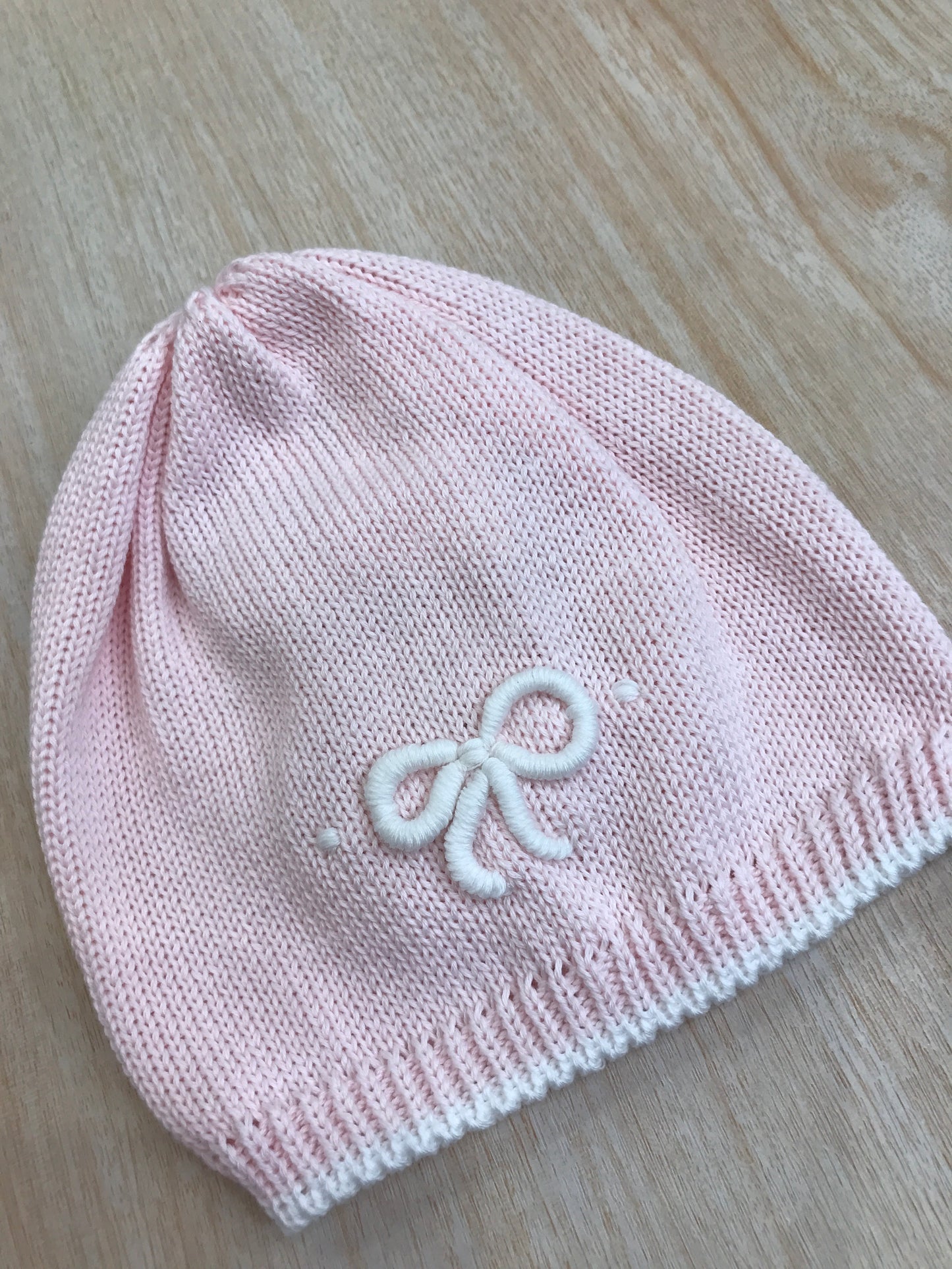 Cappello Bebè di Almy in filo rosa con fiocchetto bianco ricamato sul davanti