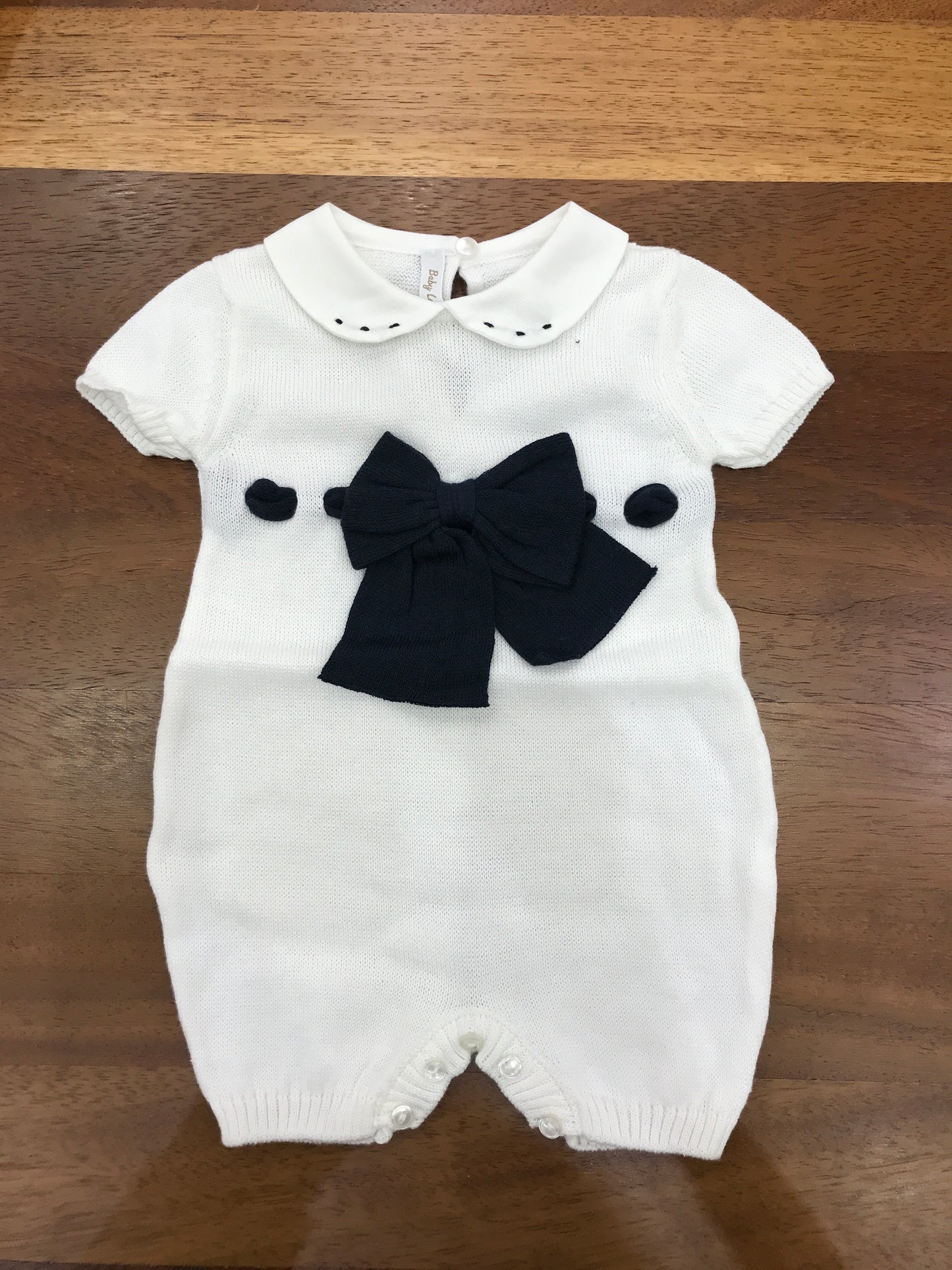 Pagliaccetto Baby Lord in filo bianco mezza manica con fiocco e passanastro blu con collo tondo bianco con pois blu