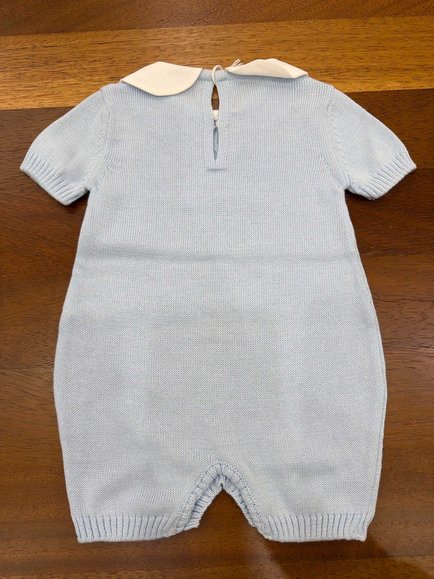Pagliaccetto Baby Lord in filo celeste mezza manica con lavorazione di trecce con collo tondo bianco
