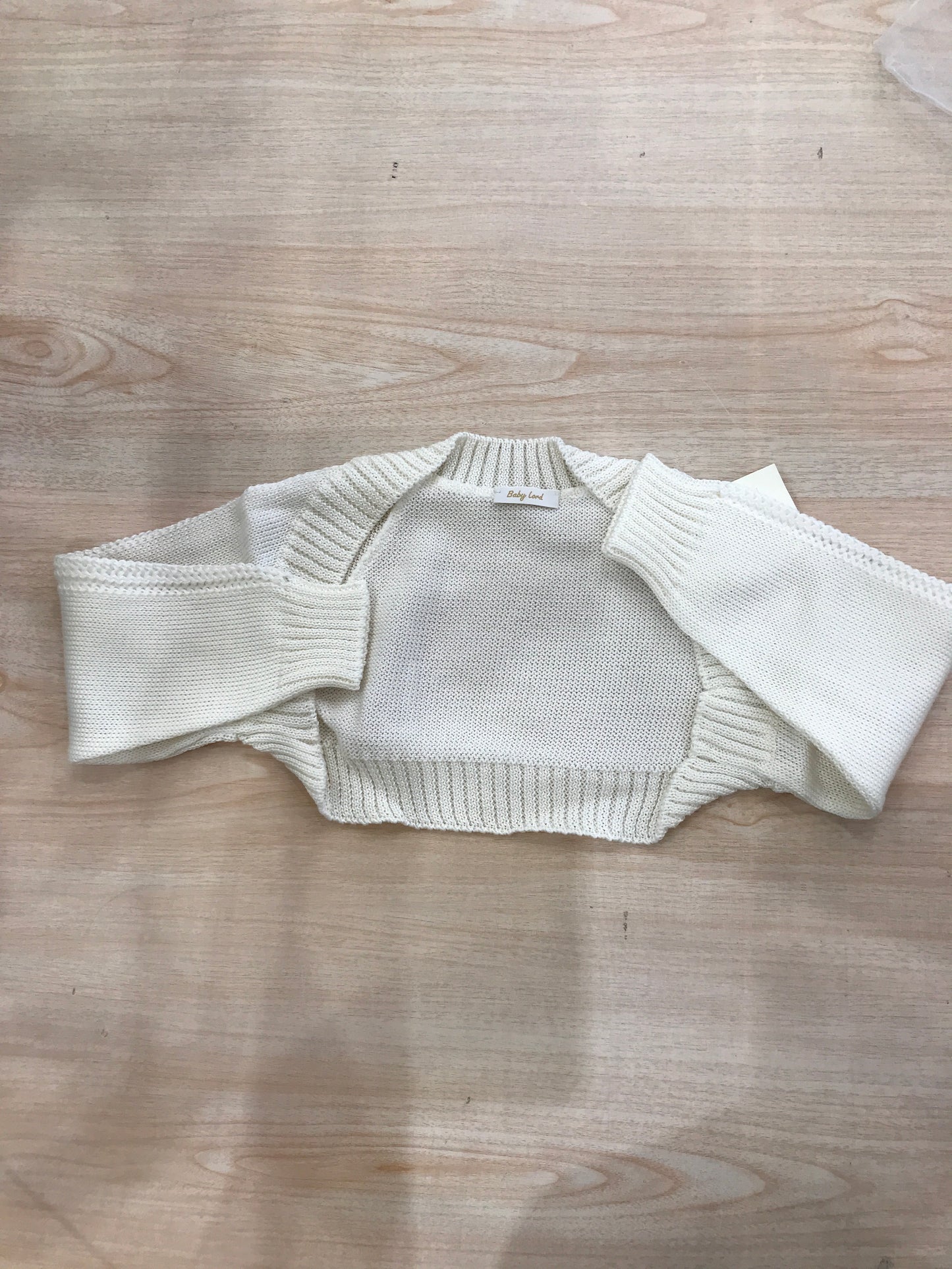 Cardigan Baby Lord in filo panna aperto sul davanti