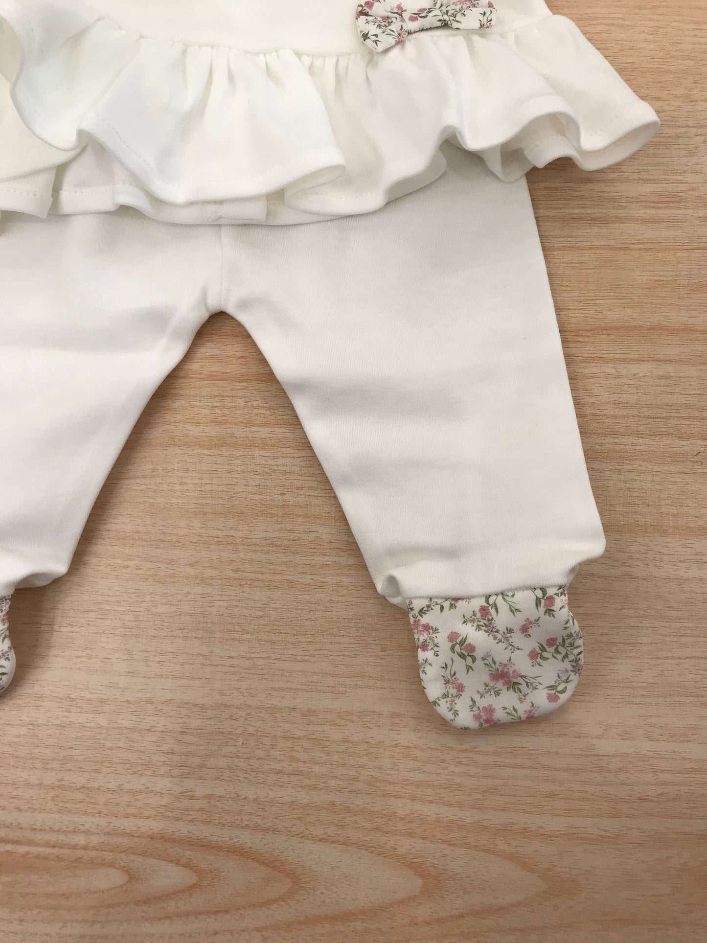 Tutina Baby Gi in cotone due pezzi manica lunga con piedini decorati da fiorellini rusche colletto con fiorellini e fiocchetto laterale in basso