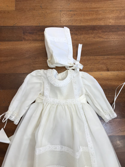 Abito lungo Belan in battista di cotone con tulle e pizzo con pieghe lavorato sul davanti manica lunga con cuffietta coordinata