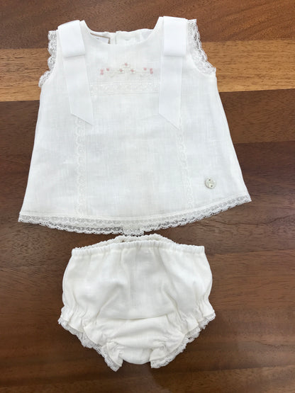 Completo Paz Rodriguez in lino bianco con fiocchi sulle spalle con merletto con fiori ricamati sul davanti con culotte e cuffia abbinata