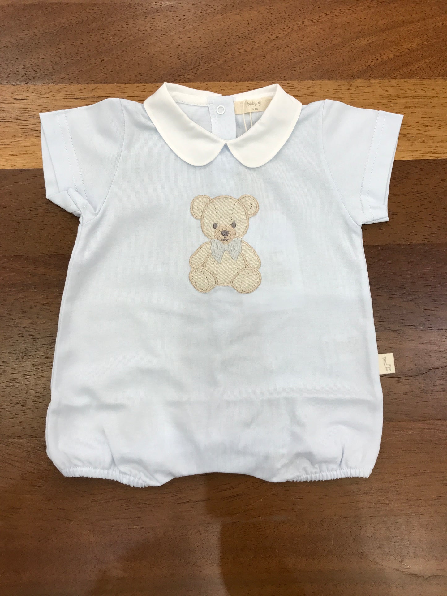 Pagliaccetto Baby Gi celeste corto mezza manica con collo tondo con orsetto applicato sul davanti con fiocco